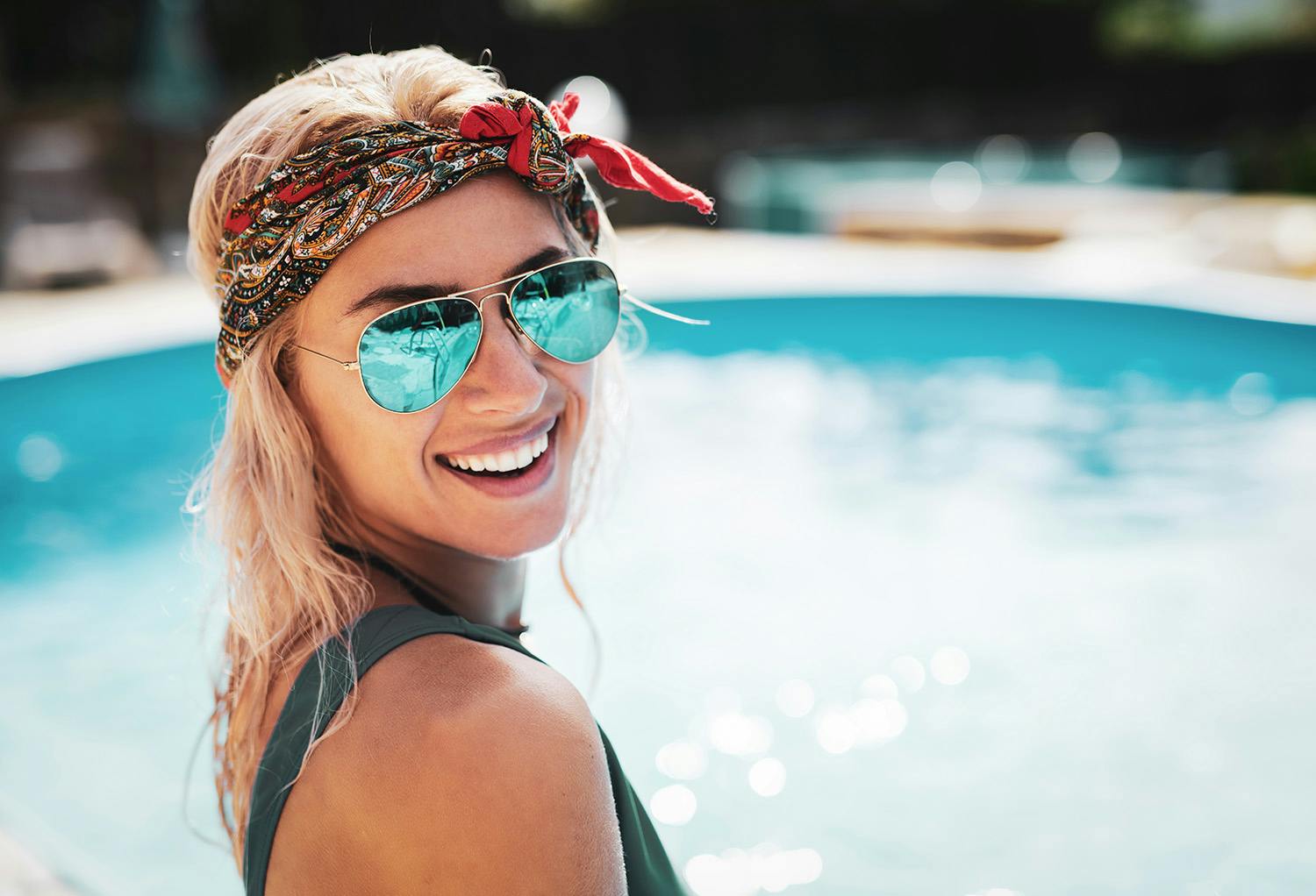 Woman with Sunglasses and a Bandana Sitting by the Pool