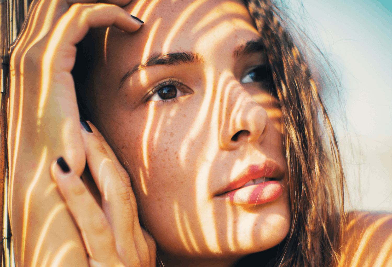 Close Up of Woman's Face in Her Hands with Shadow