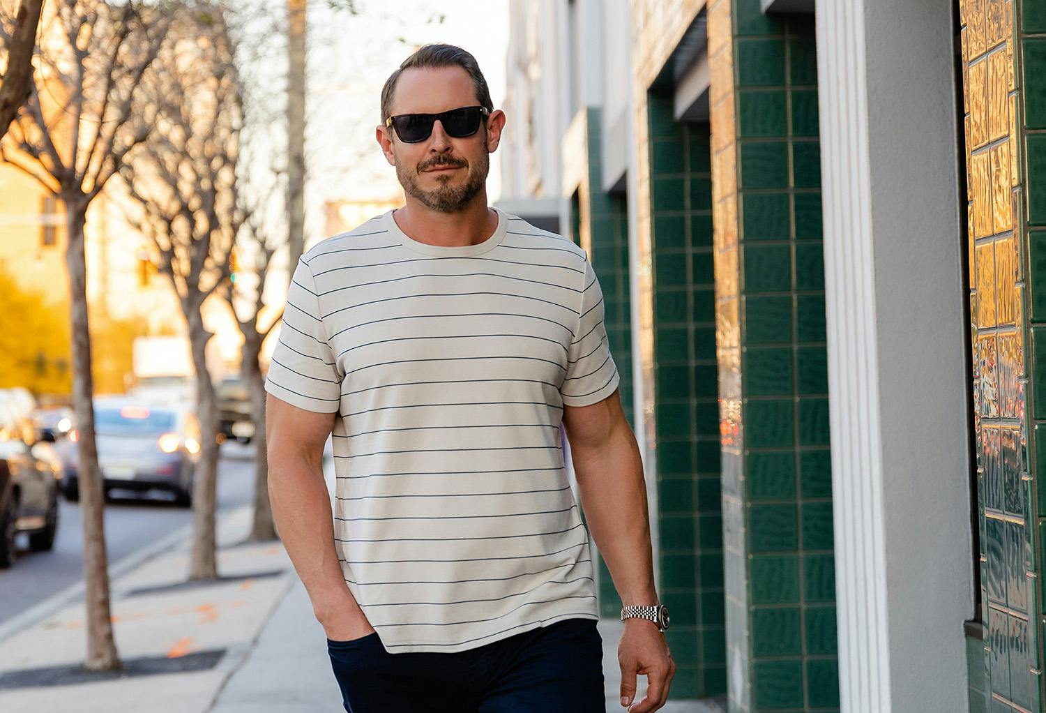 Man Walking with Sunglasses and a Striped Shirt