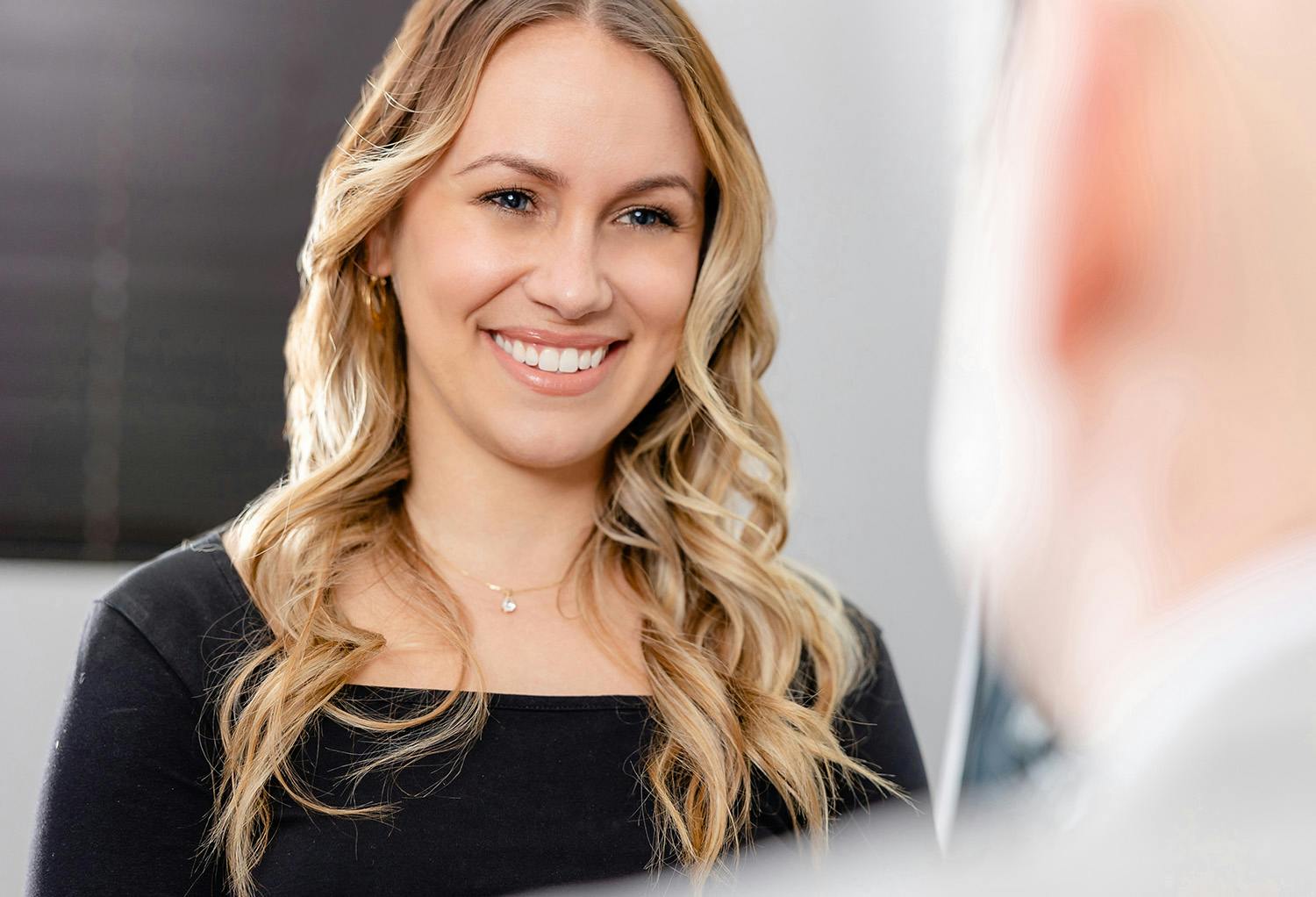 Woman with Blonde Hair and Black Shirt Smiling