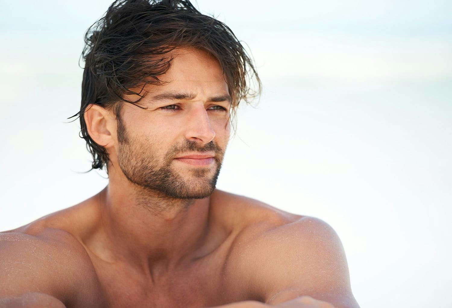 Shirtless Man from the Shoulders Up Thinking on the Beach