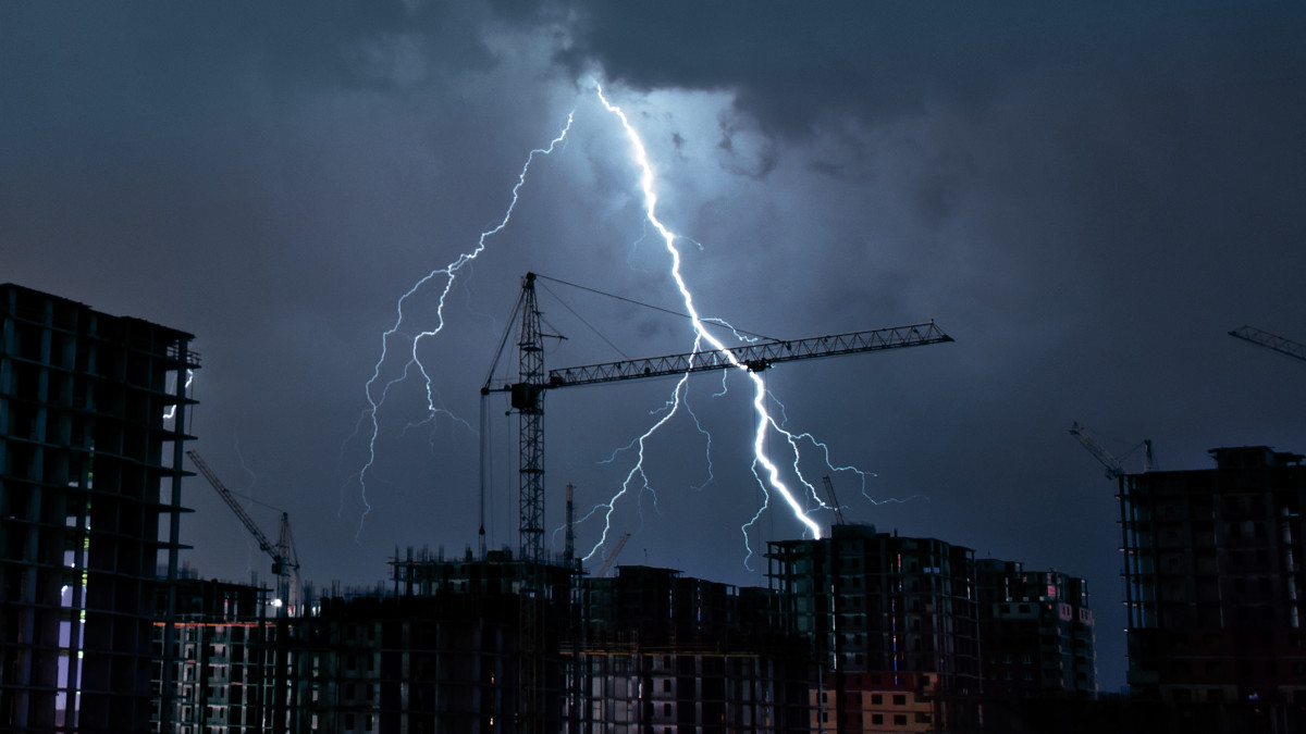 Lightning strikes a building construction site at night