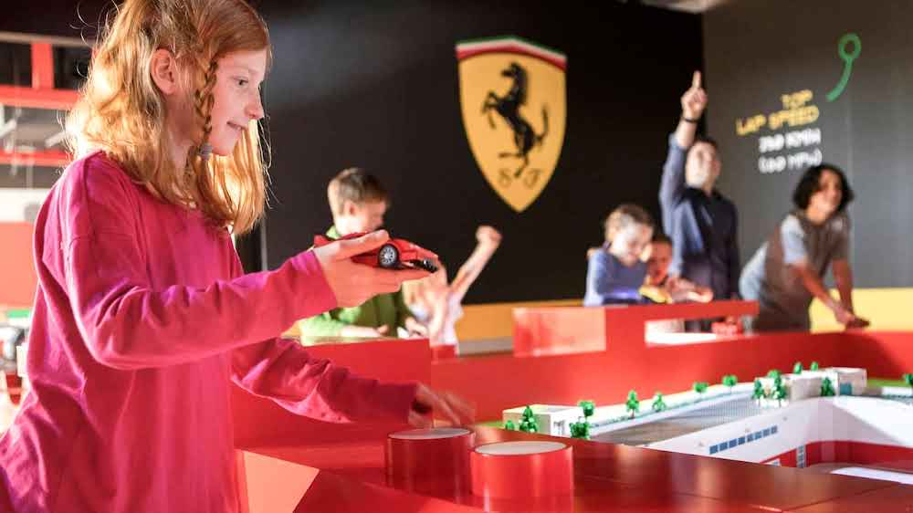 Child Holding a Ferrari Car Built from Legos at the Ferrari Build and Race Experience