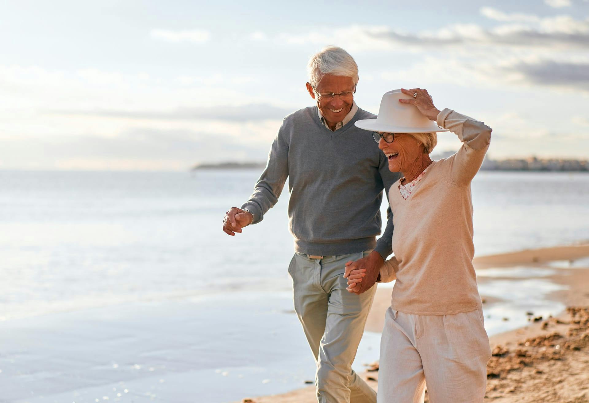 Elderly man and woman walking down the beach