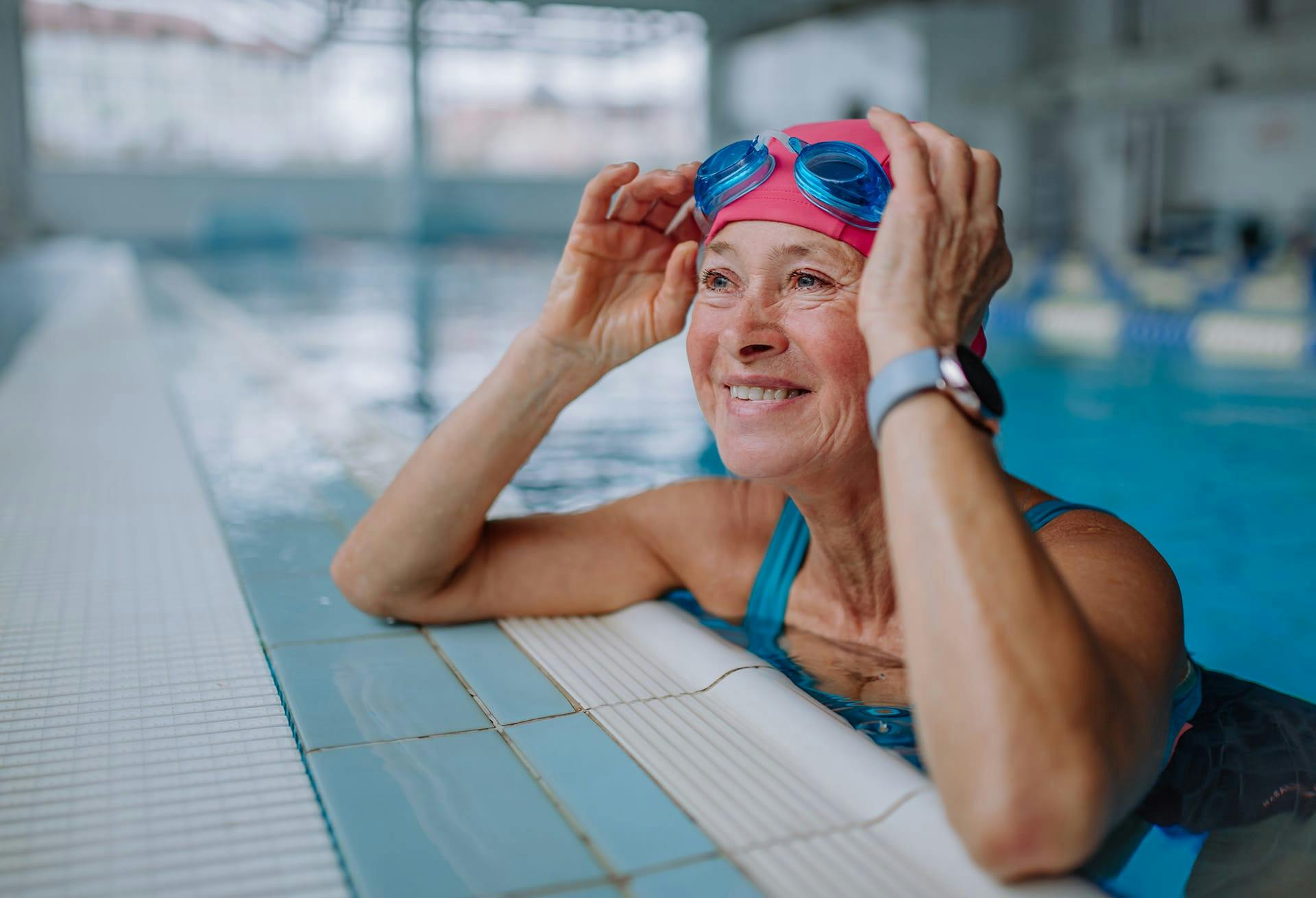 Woman in a swimming pool with cap and goggles