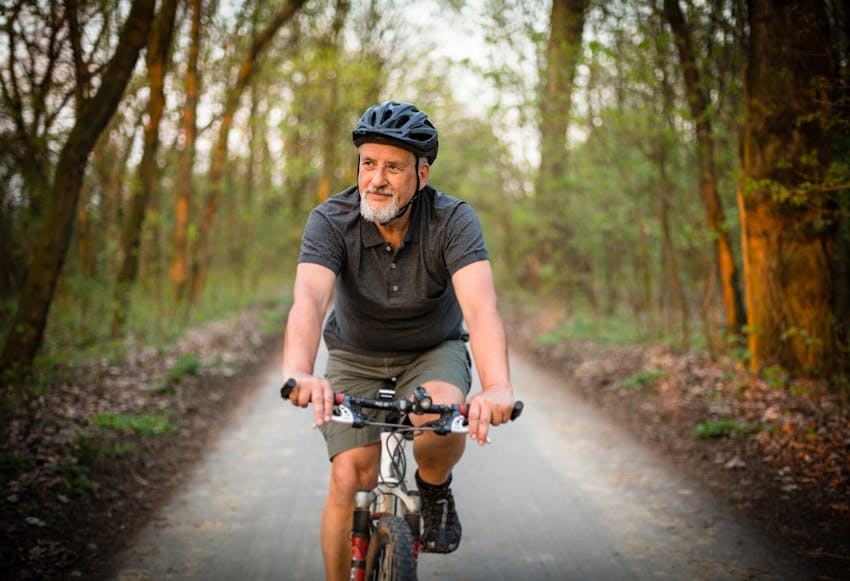 Guy riding a bike down a path