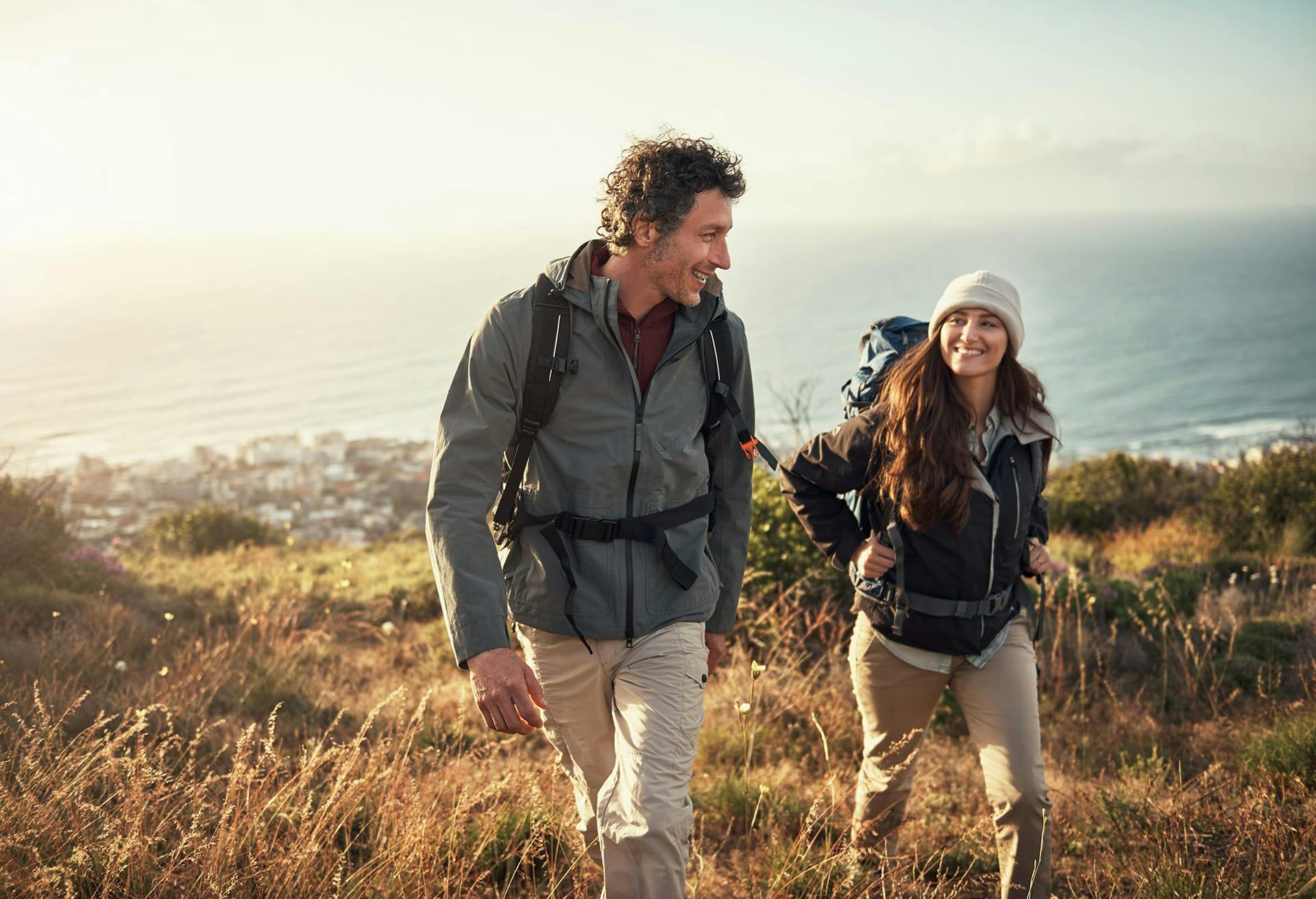 Man and woman hiking in the hills with backpacks on
