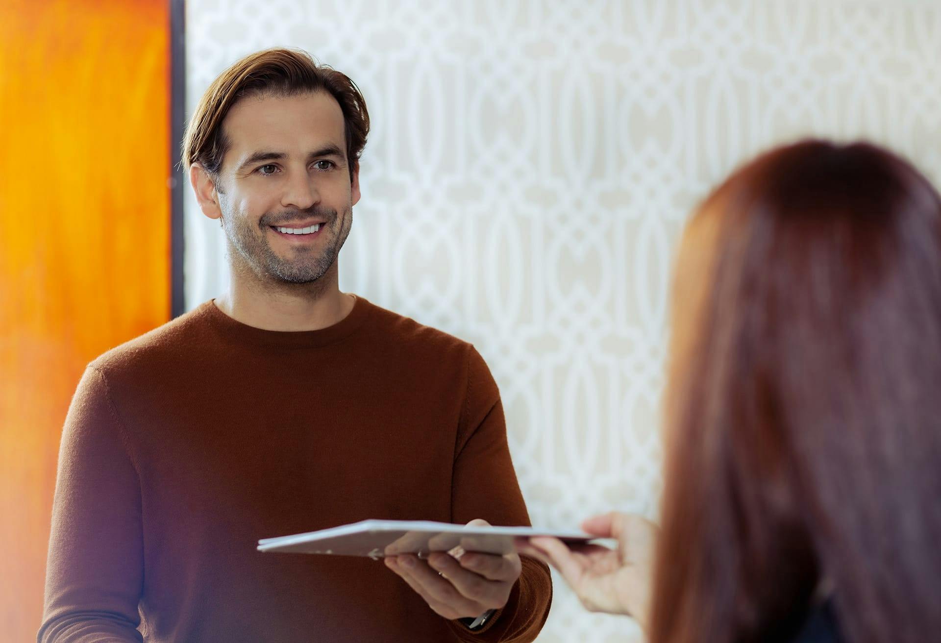 Patient holding forms in his hand