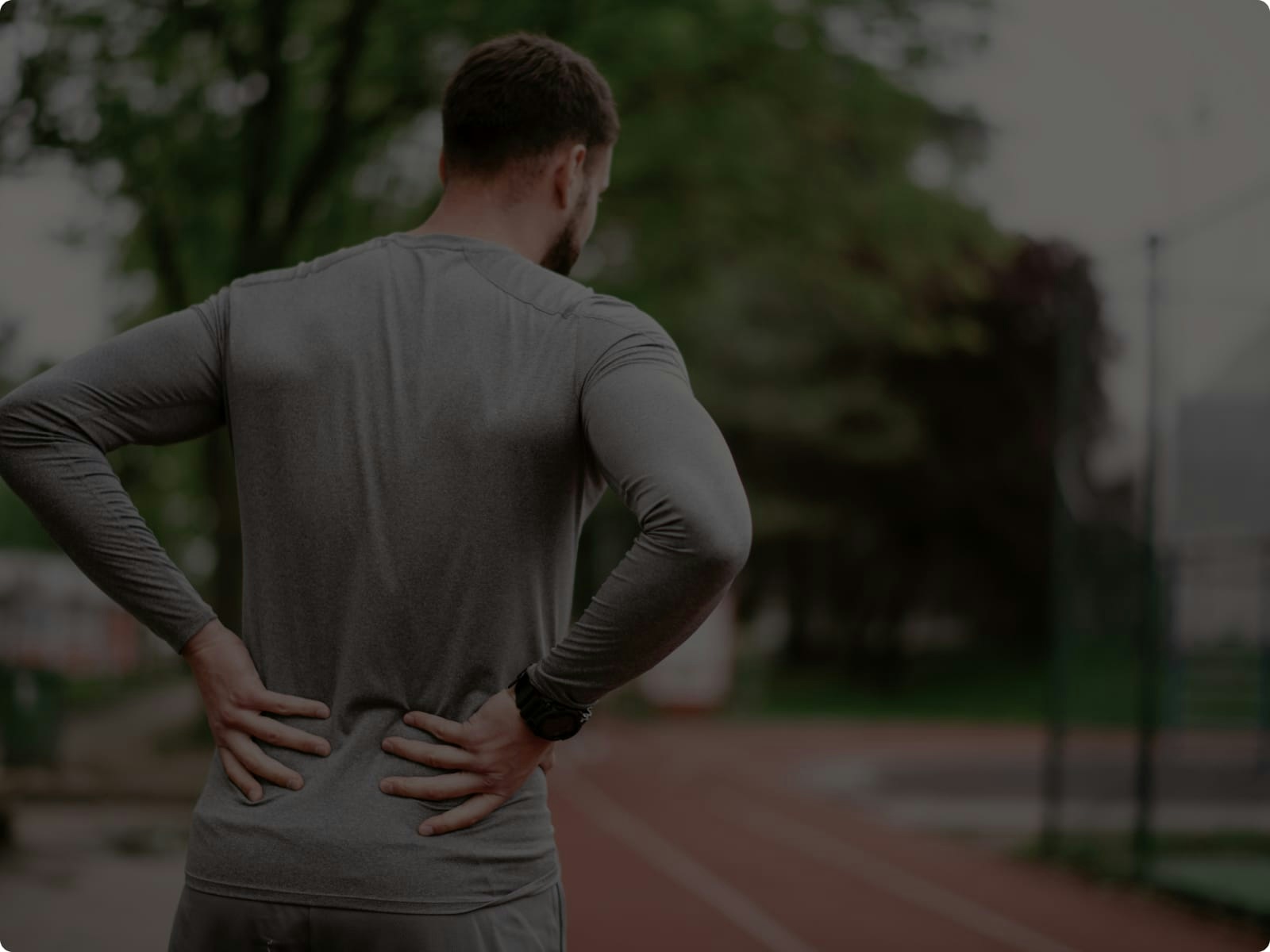 Man grabbing his back on a track
