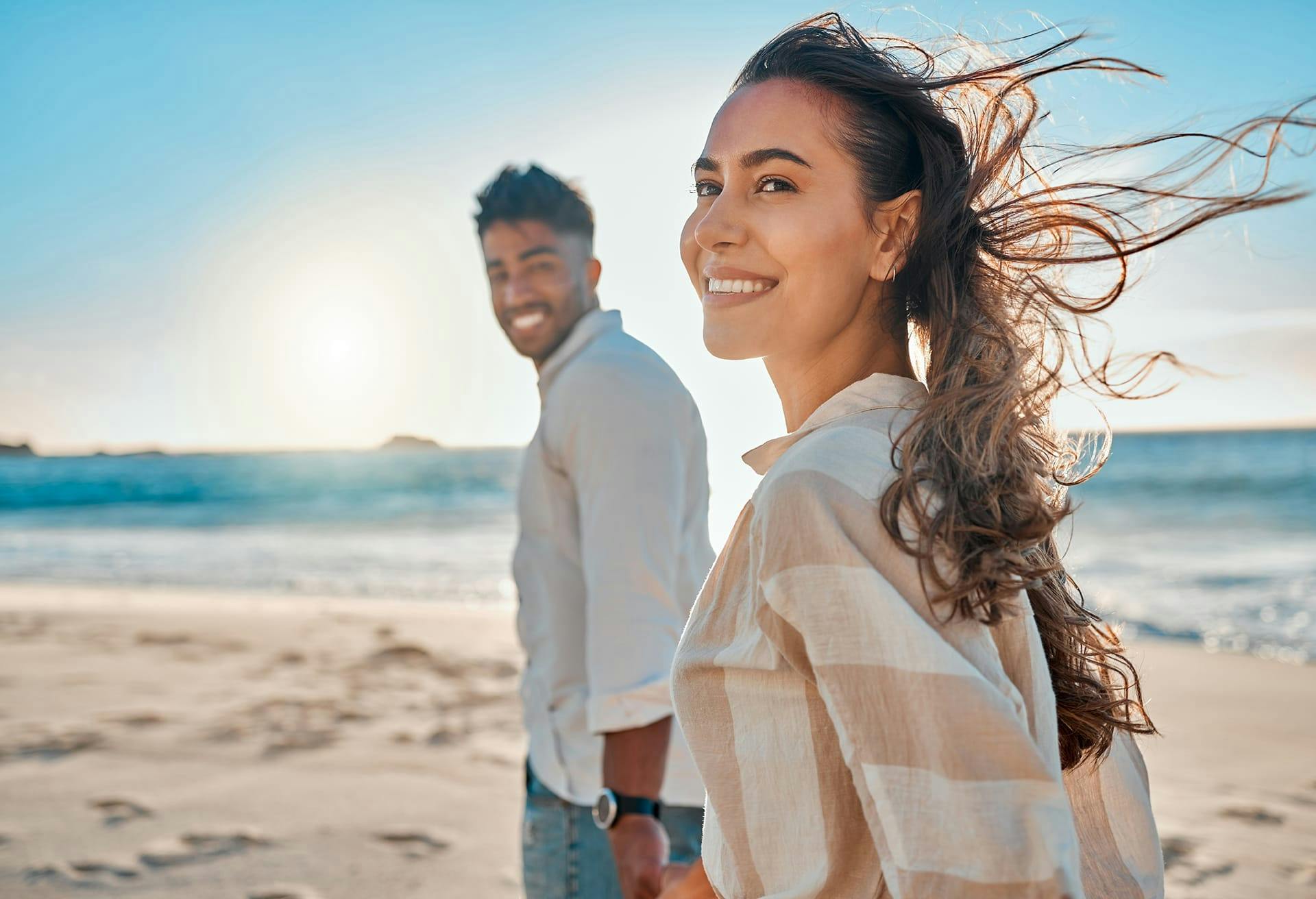Man and woman on the beach, smiling