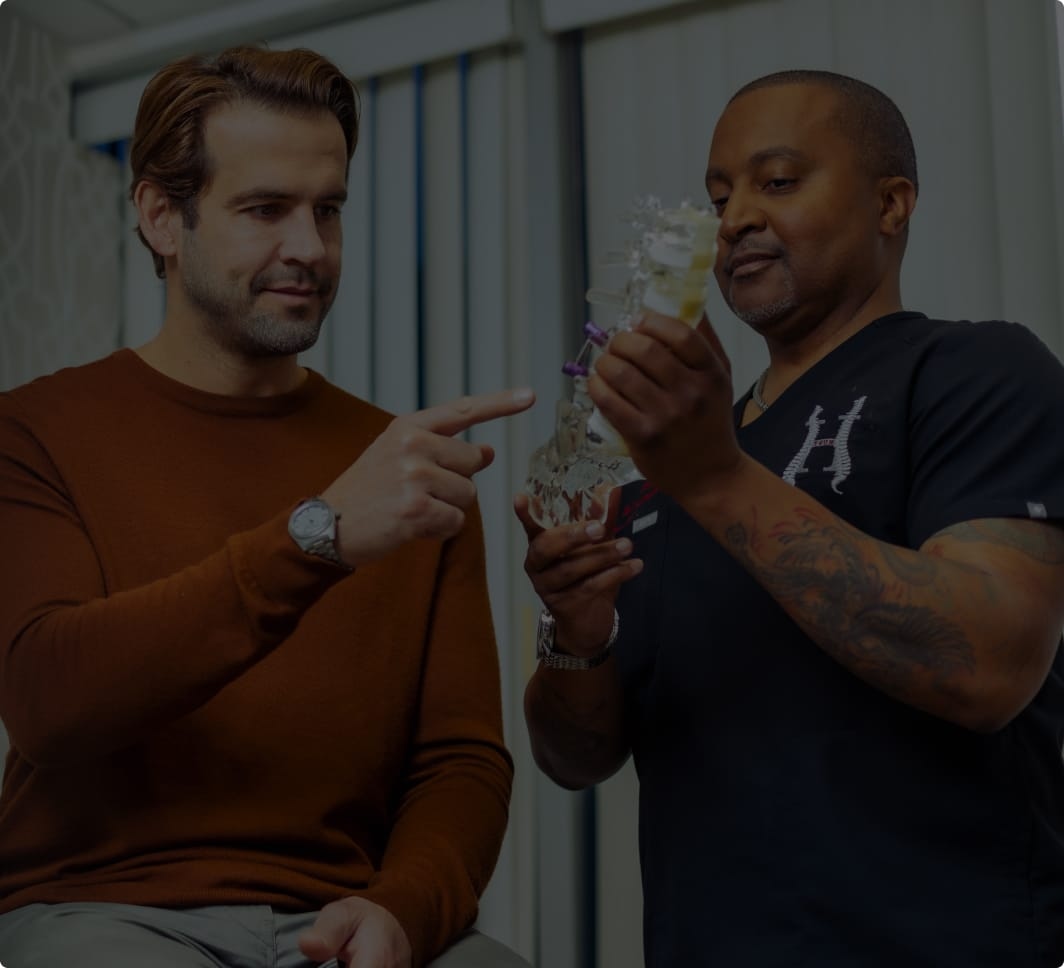 Dr. Leonel Hunt showing a patient a model of a spine