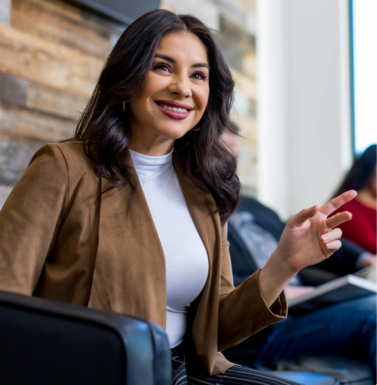 Smiling woman sitting with other people.
