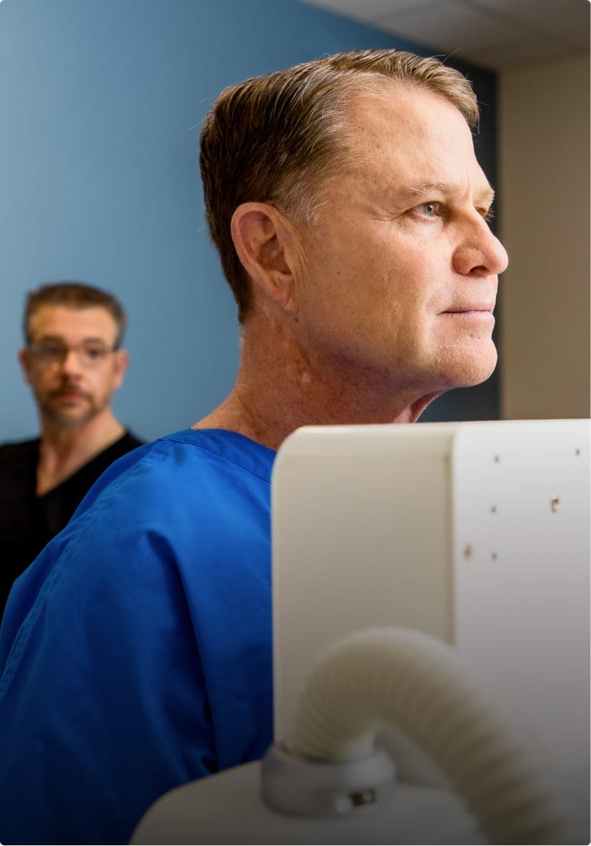 Two men working and wearing scrubs.