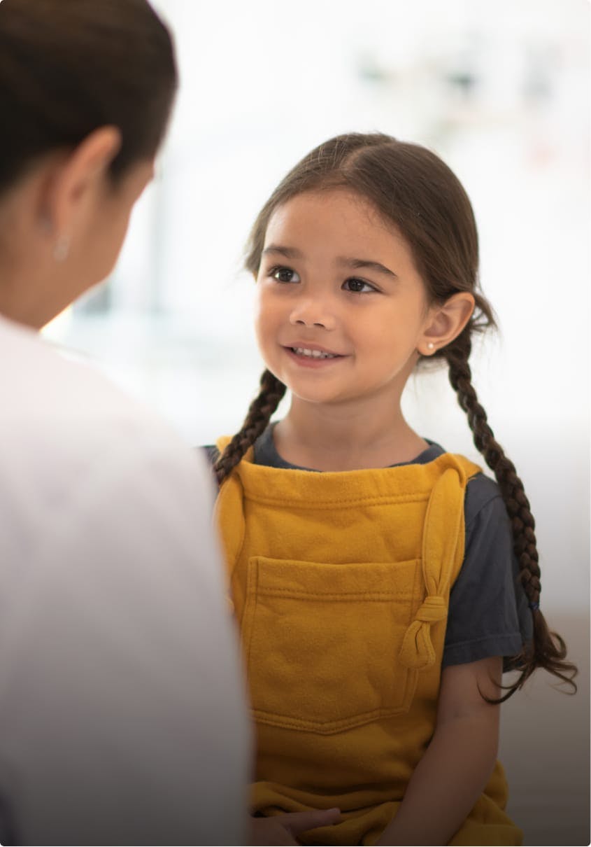 A professional woman helping a little girl.