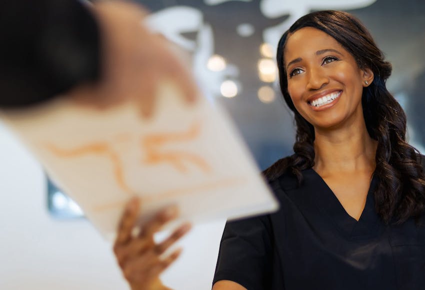 Patient handing paper to Longhorn Imaging staff