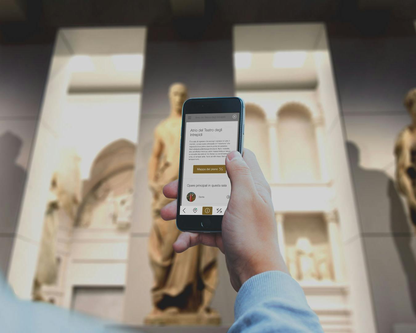 Una persona tiene un smartphone delante de estatuas clásicas en un museo, mostrando una aplicación de información sobre arte en la pantalla.