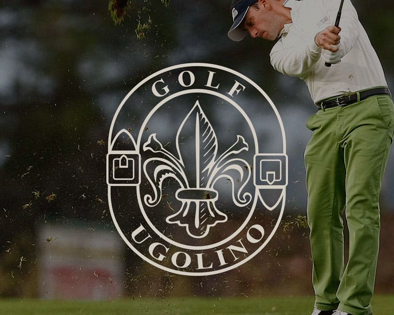 Un uomo in abbigliamento da golf esegue un potente swing su un campo da golf, con zolle di terra che si sollevano dal terreno; il logo di Golf Ugolino è sovraimposto in primo piano.