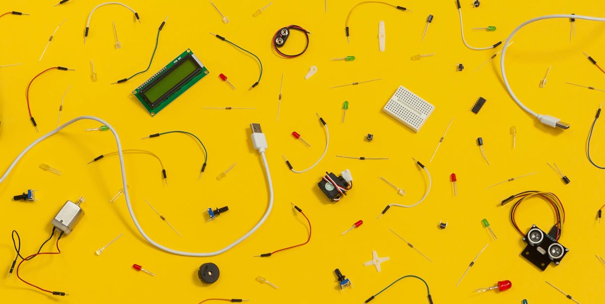A yellow background with electronics bits and pieces from an arduino board