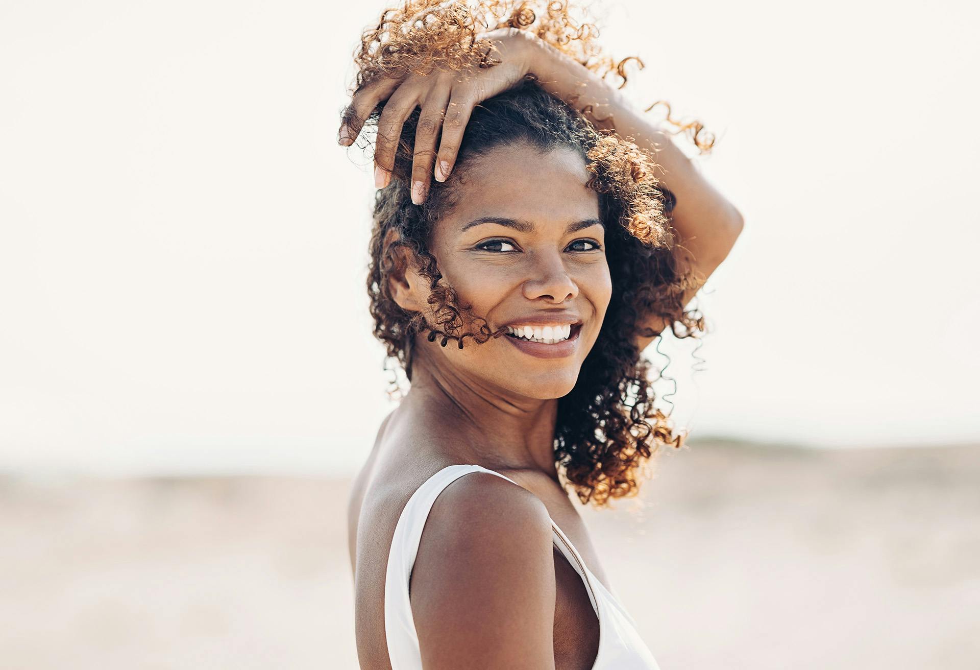 Woman with very curly hair smiling