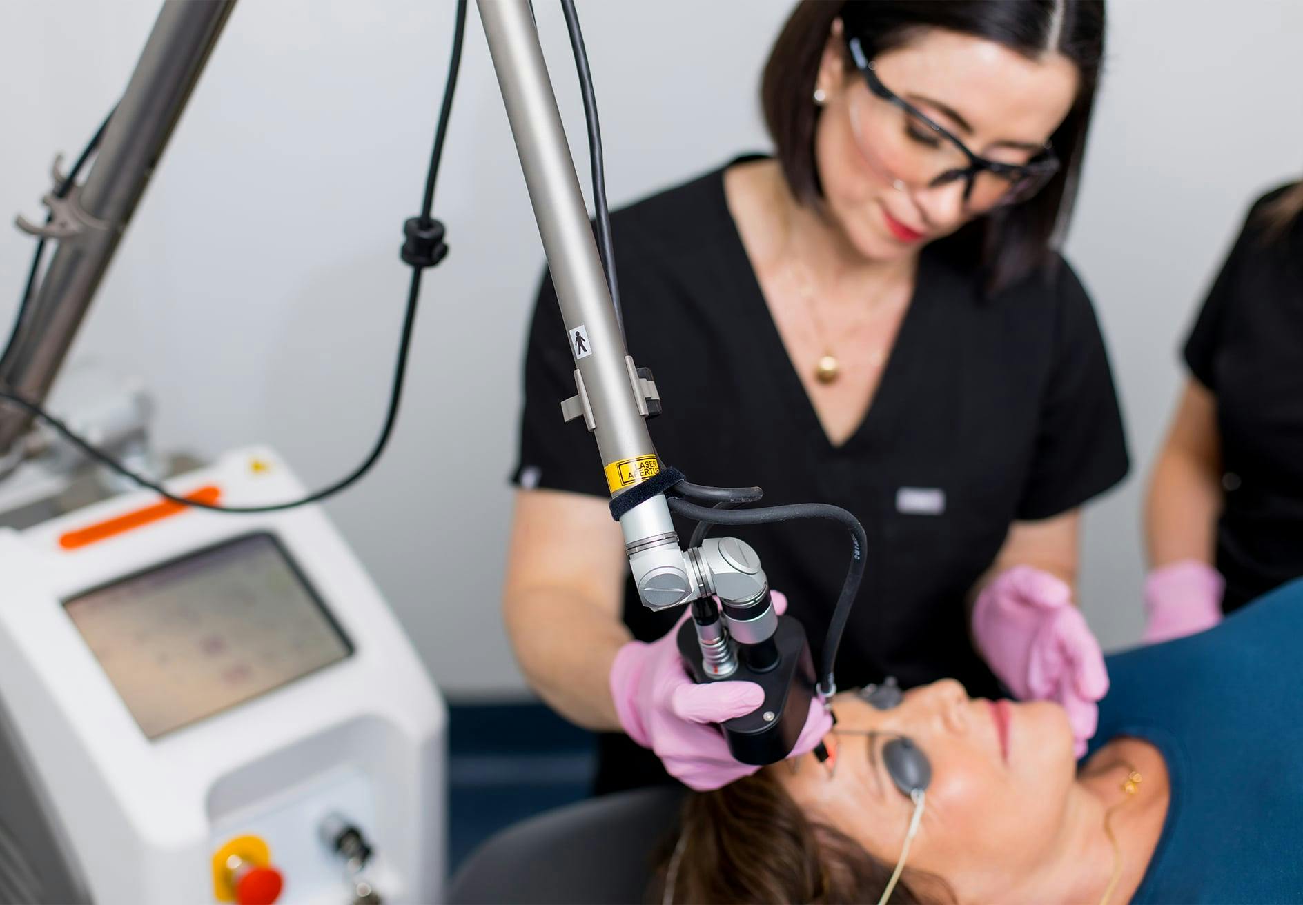woman getting a laser treatment by Dr. Helen Moses