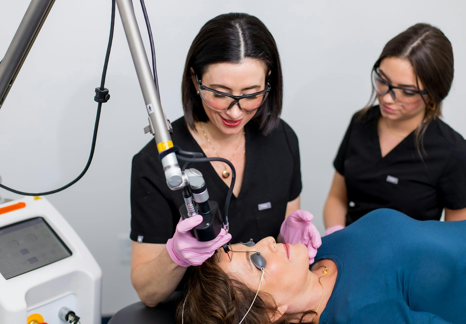 Dr. Helen Moses administering laser treatment with assistant