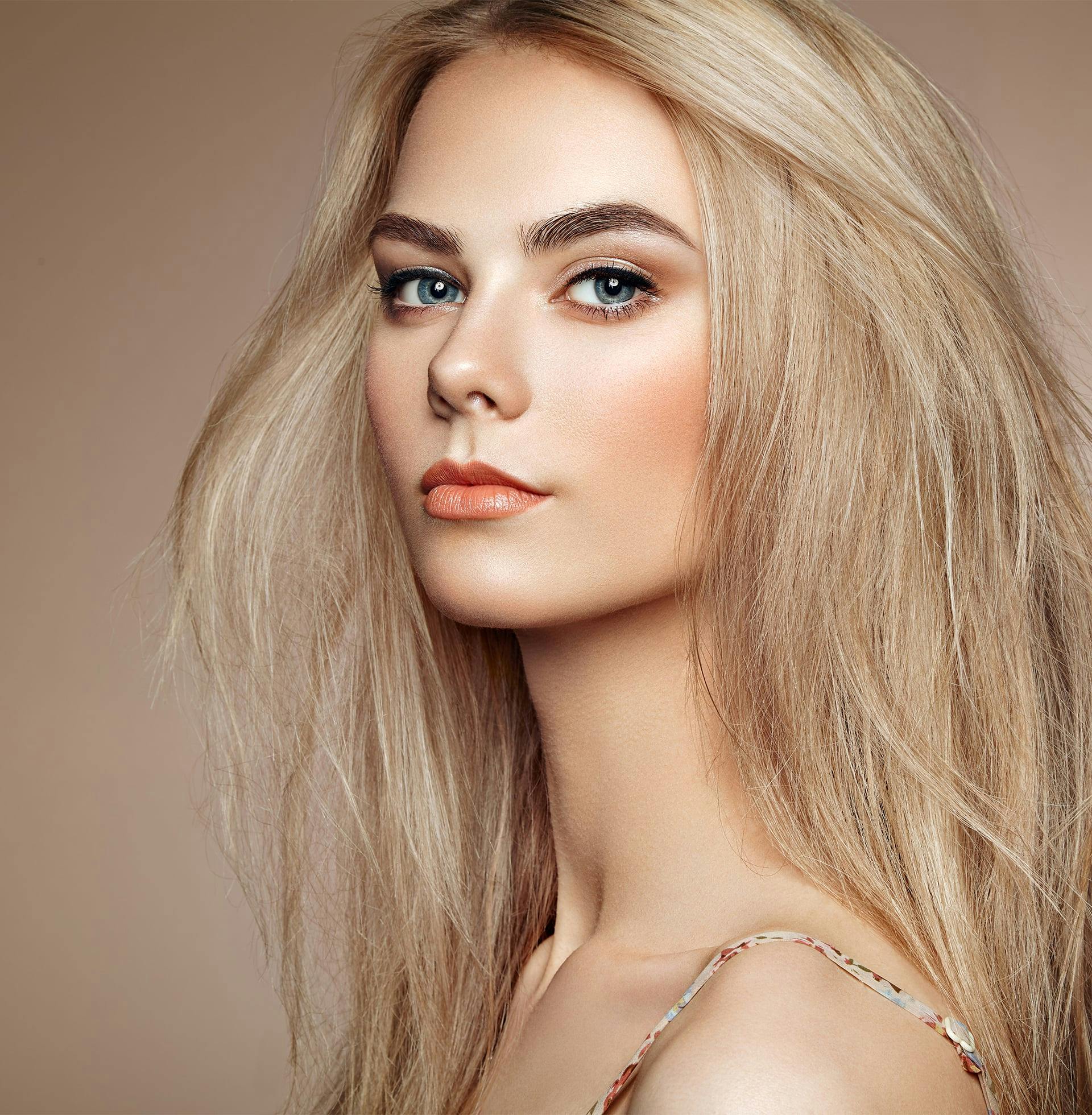 blond woman with long, straight hair and blue eyes posing for a picture