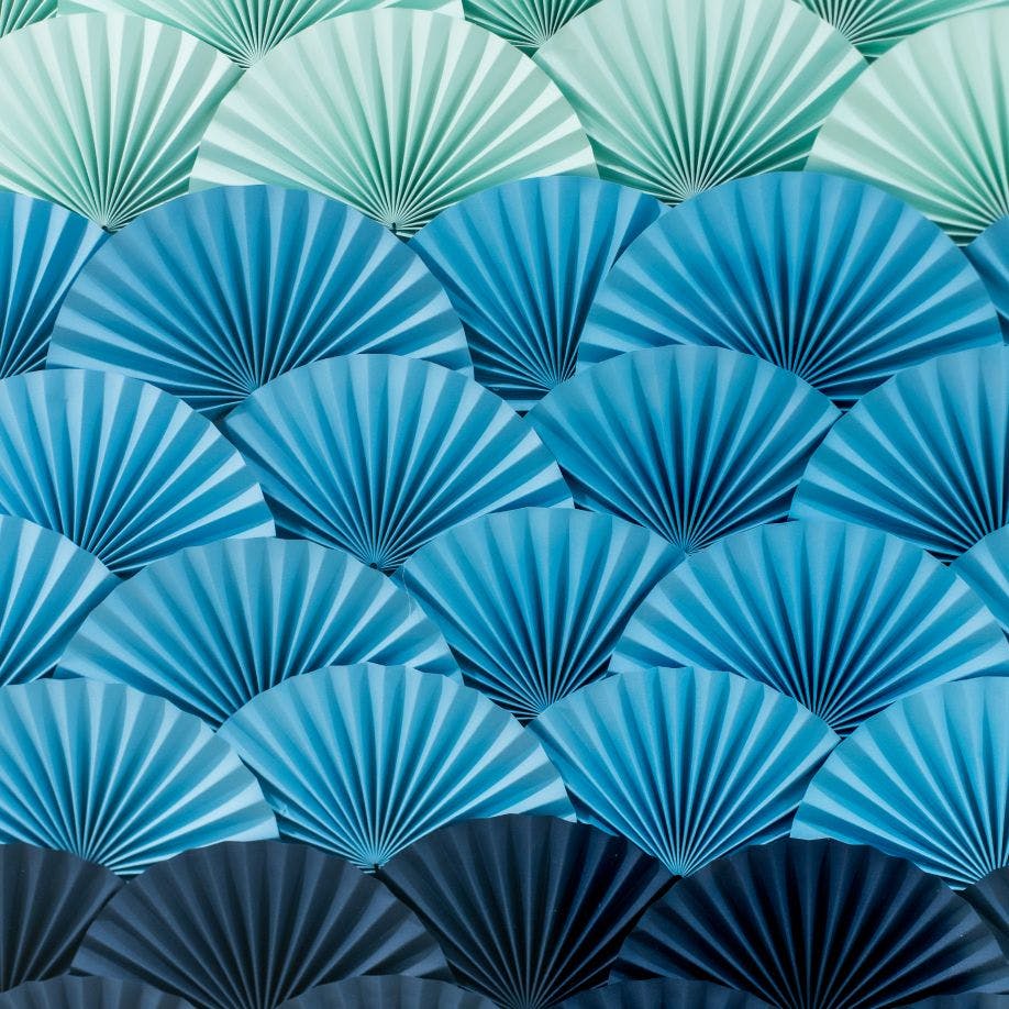 a close up of a wall made of blue and green paper fans