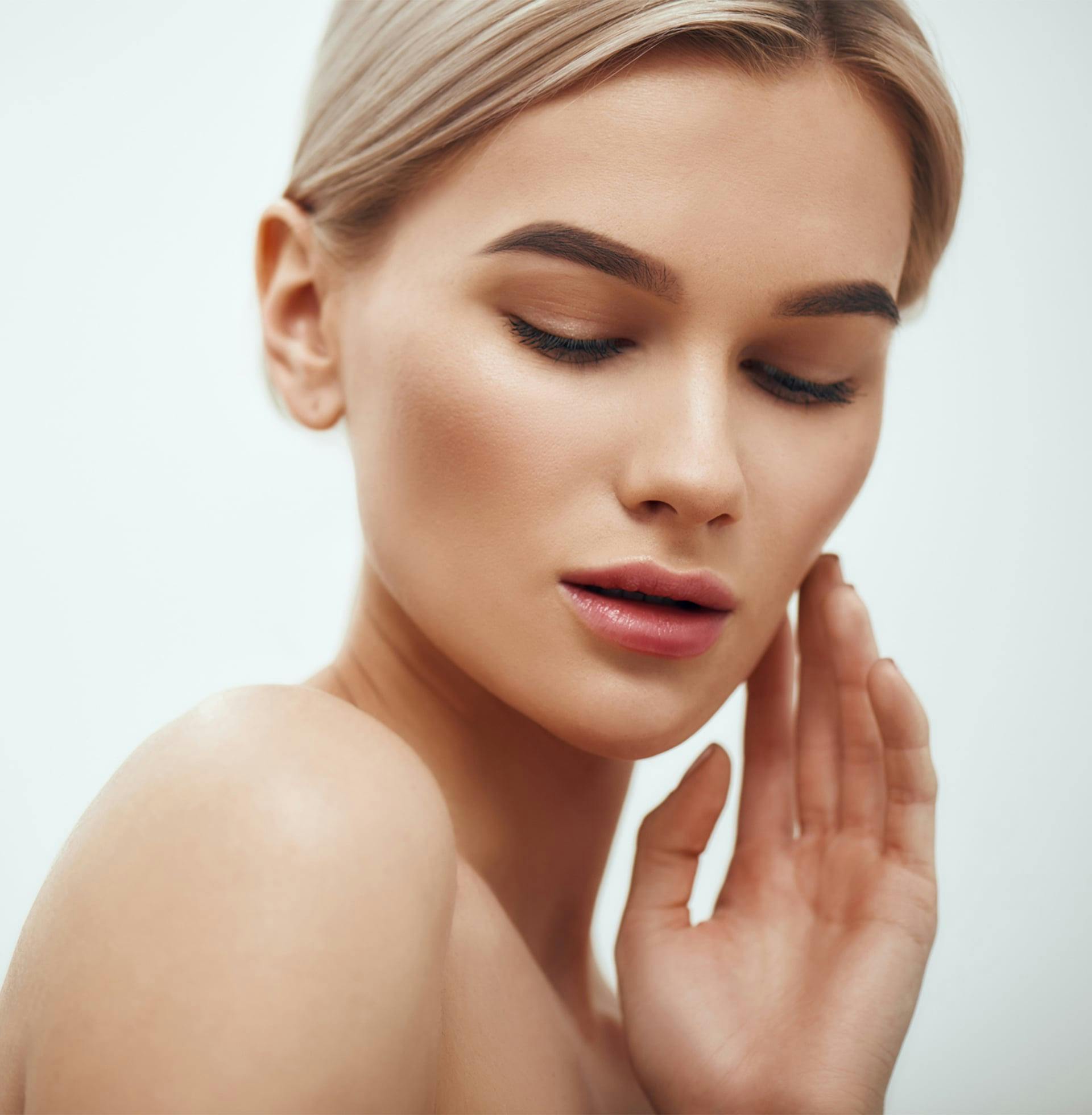 woman touching face and posing for camera