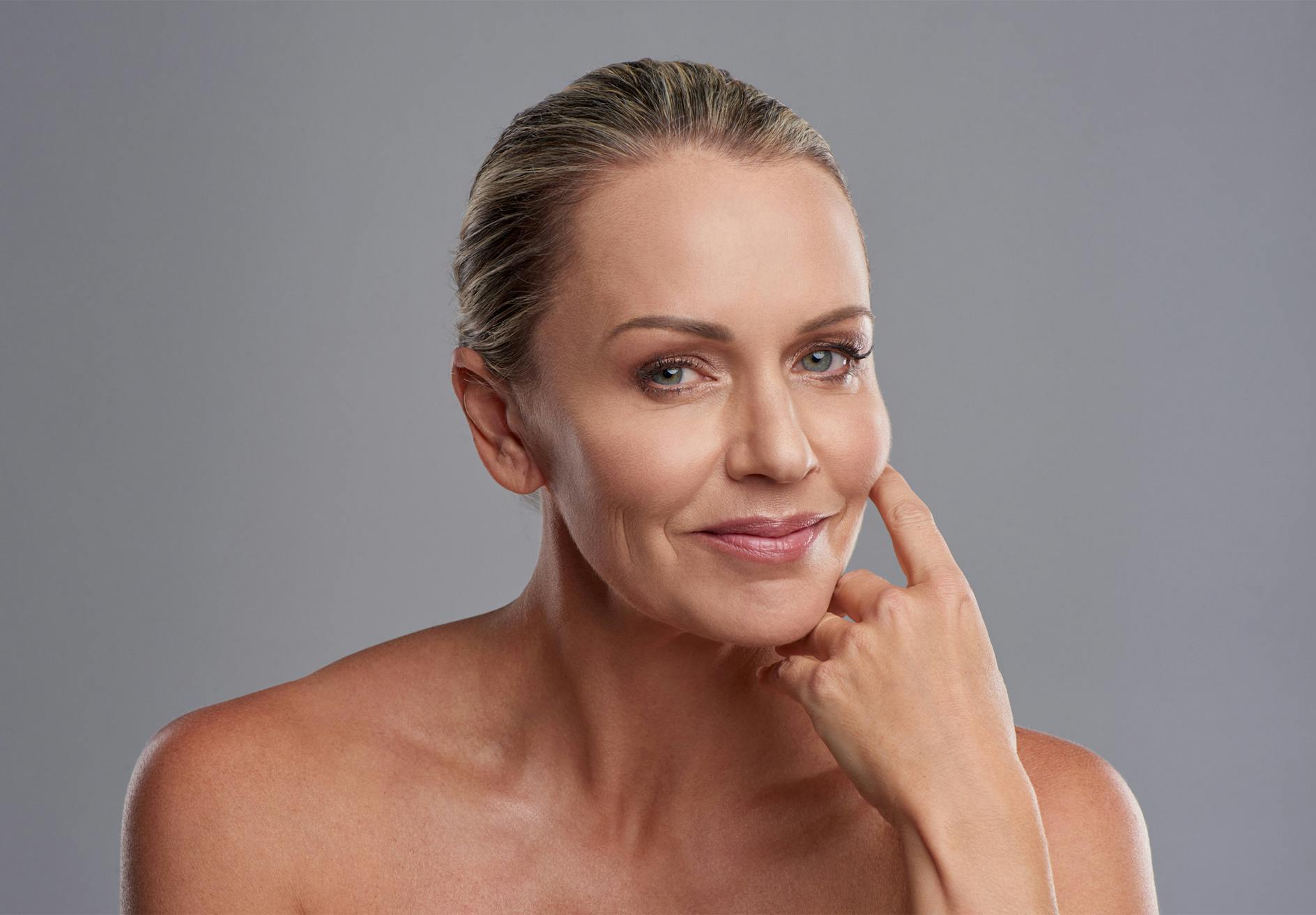 blond woman with a clean face and no shirt posing for a picture