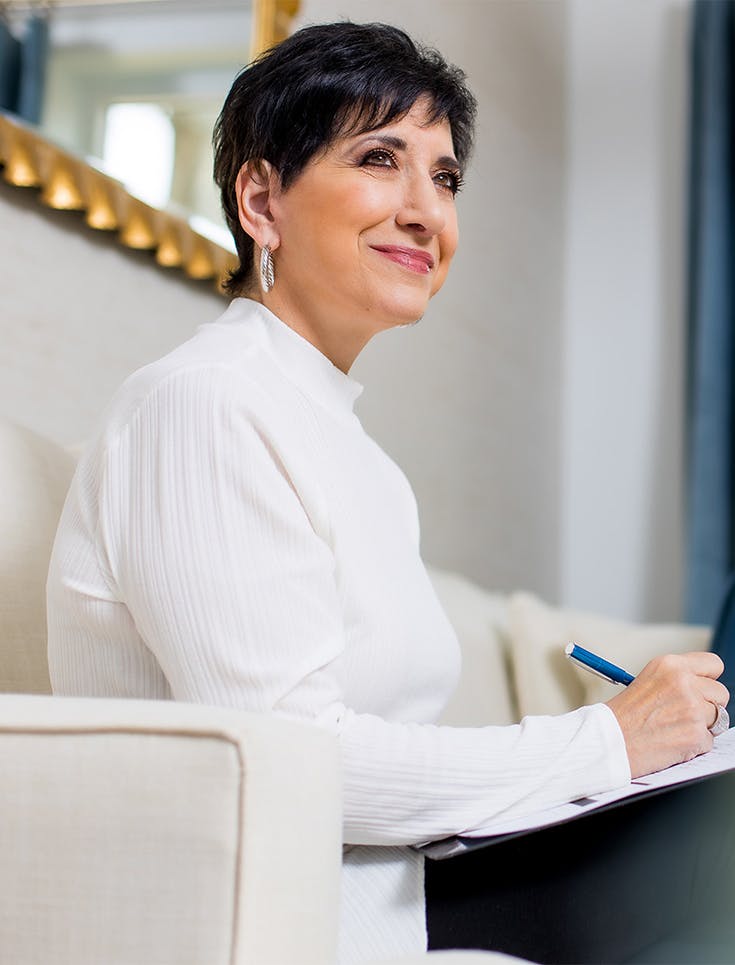 Woman sitting on couch with a clip board
