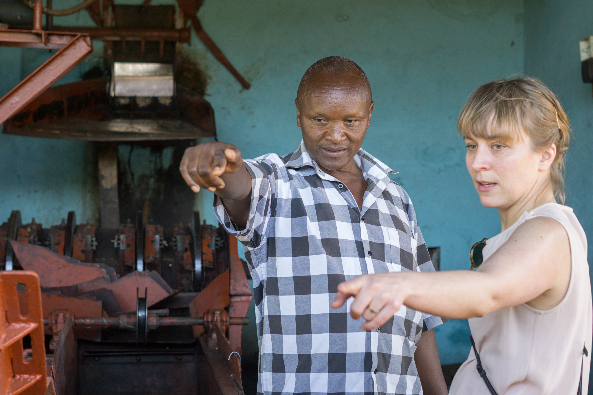 Kieni mill manager Jospath Kariuki explaining the processing to Astrid