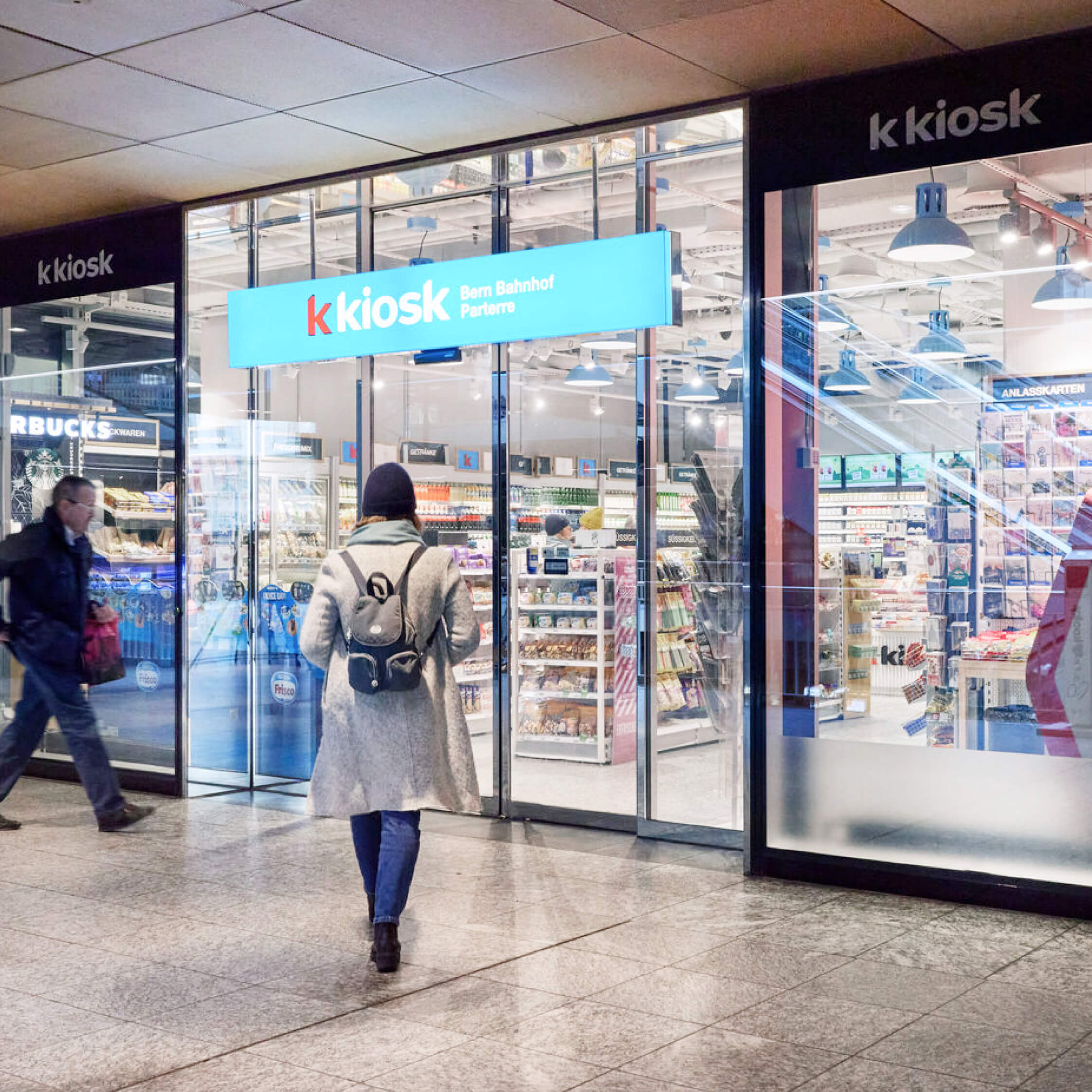 A woman entering a KKiosk branch to purchase a Cryptonow gift card.