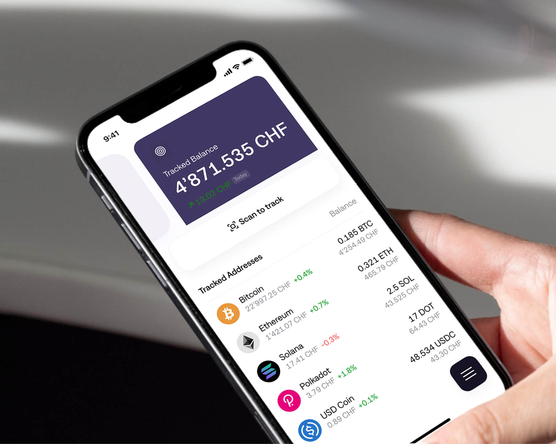 A person holding an iPhone and tracking cryptocurrency prices on the wallet app
