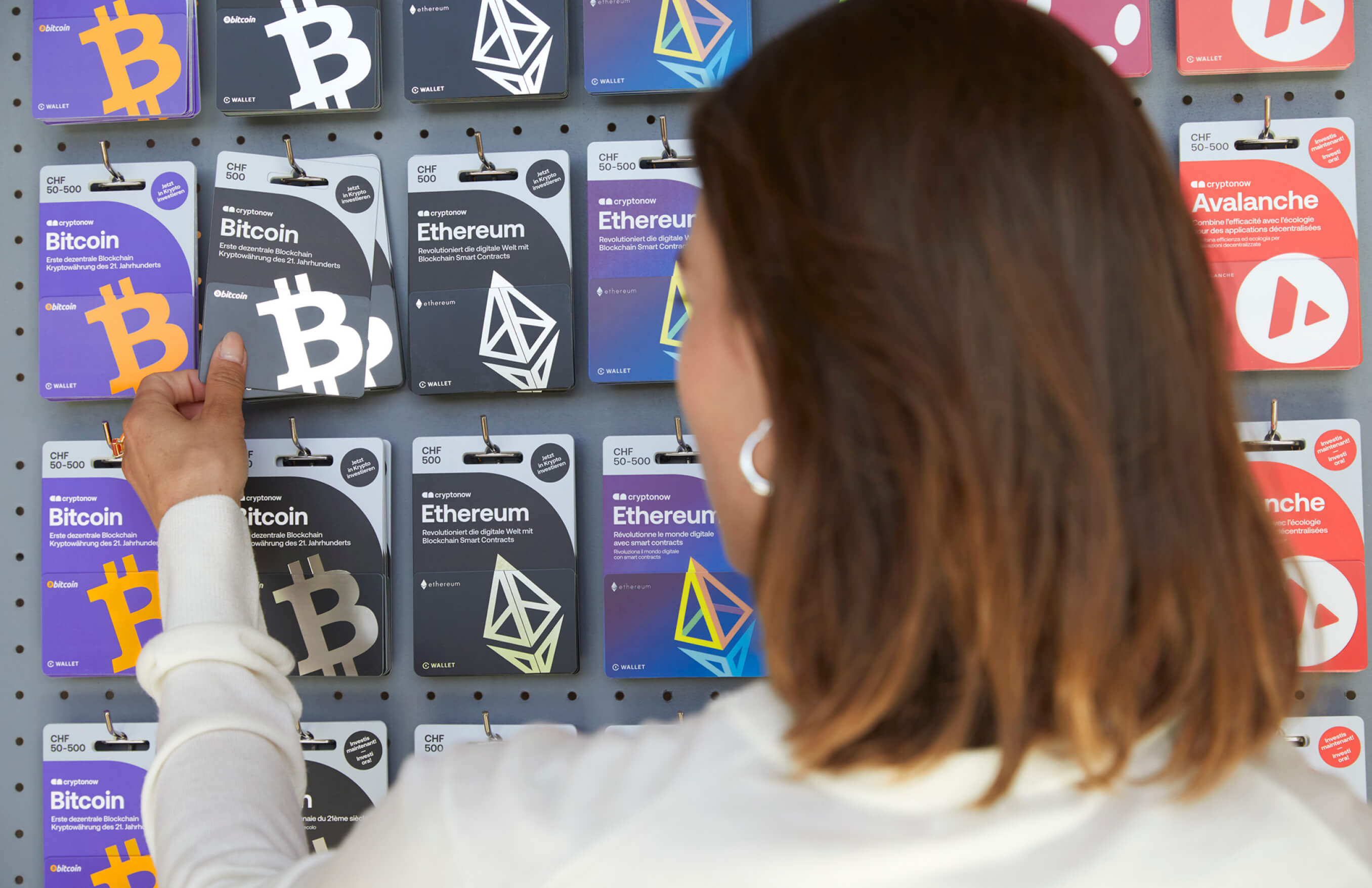 Eine Person kauft im Laden eine Cryptonow Gutscheinkarte