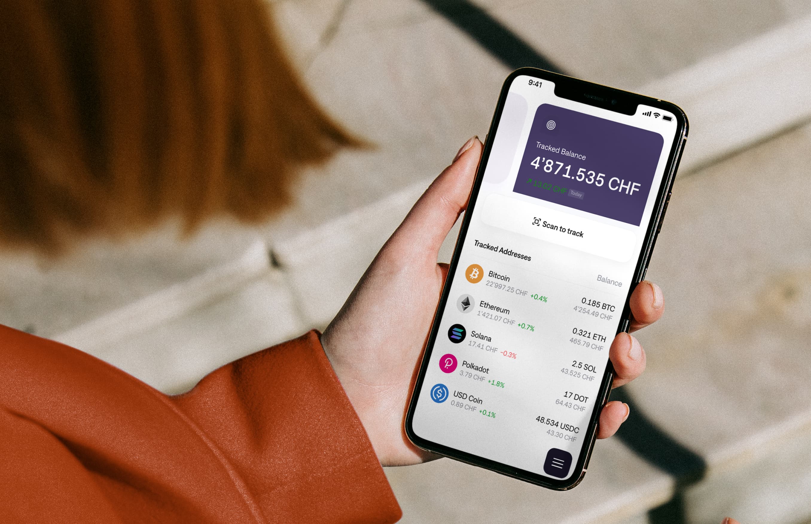 A person holding an iPhone and tracking cryptocurrency prices on the wallet app