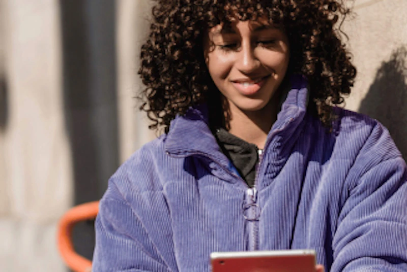 Una giovane donna guarda il suo iPad e viaggia nel suo passato di investimenti con la Cryptonow Time Machine