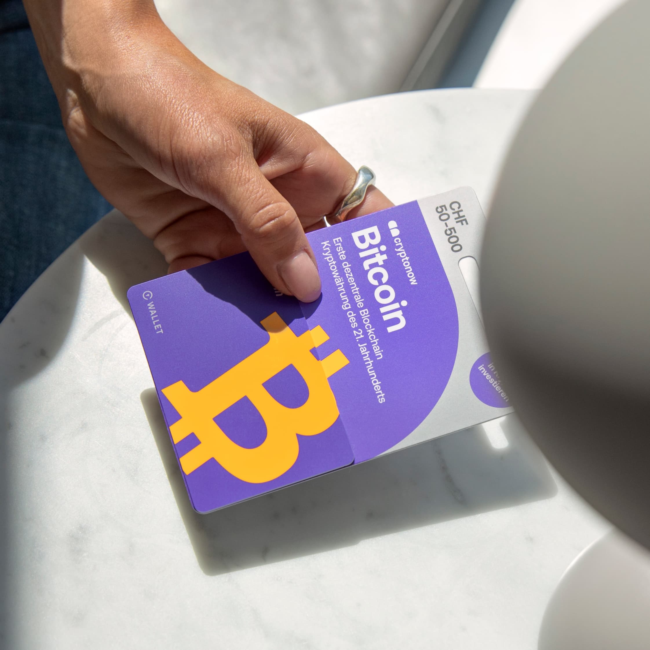 A hand holds the Cryptonow gift card with the secure offline wallet in it