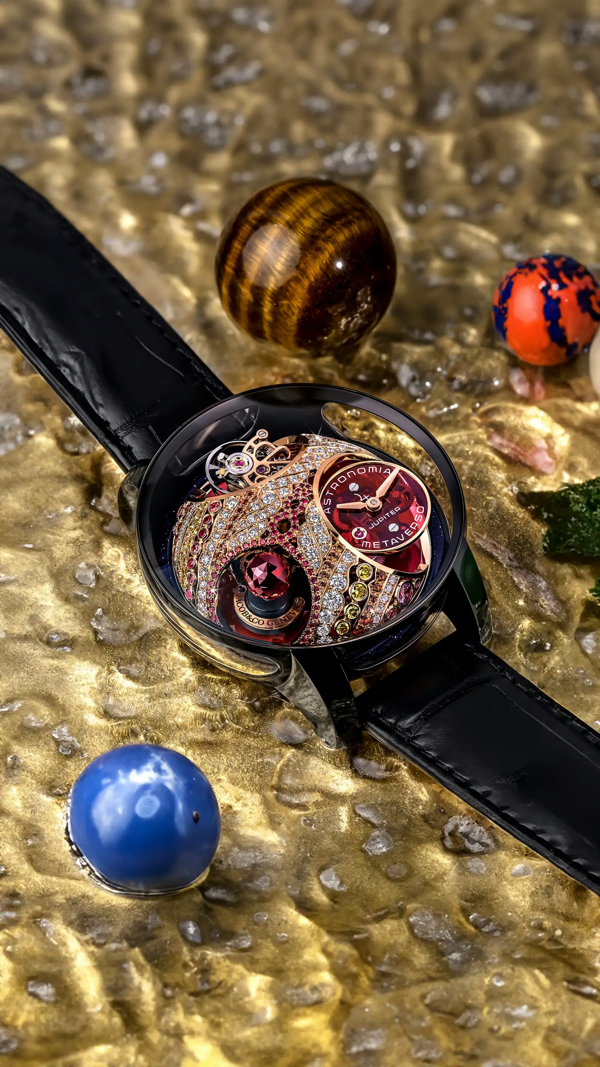 Angled view of the Astronomia Jupiter in black titanium, laid flat on a surface, next to a few spherical objects.