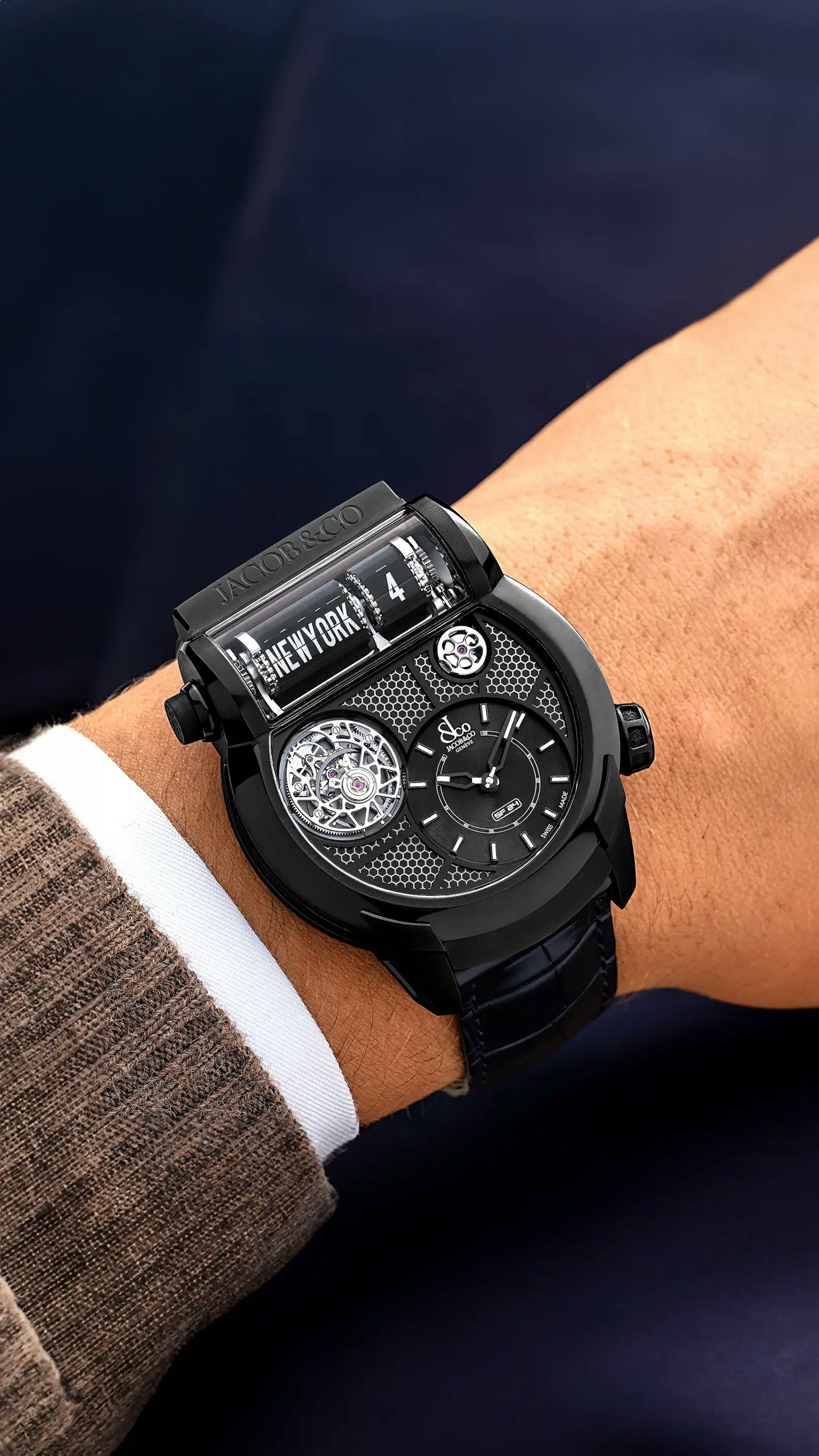 The black titanium Epic SF24 Tourbillon, with black accents and a black grid dial, worn on the left wrist.