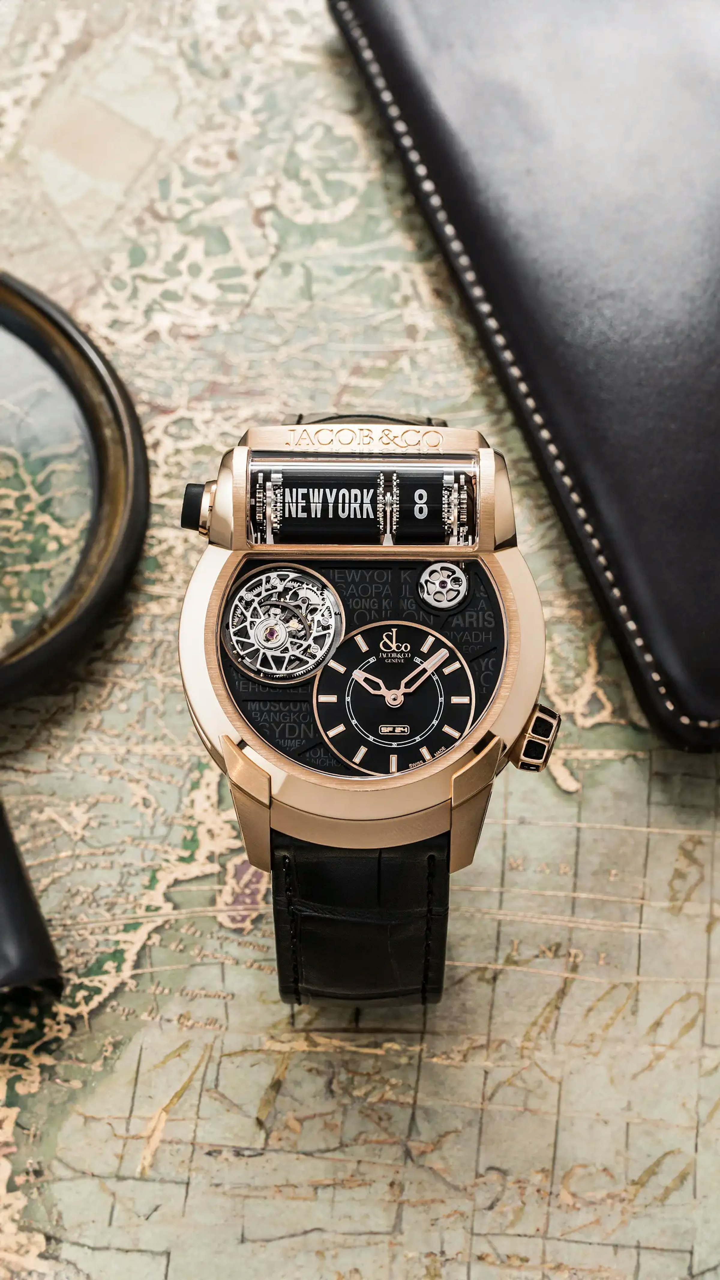 The rose gold Epic SF24 Tourbillon, with black accents and a black city dial, propped up on a surface.