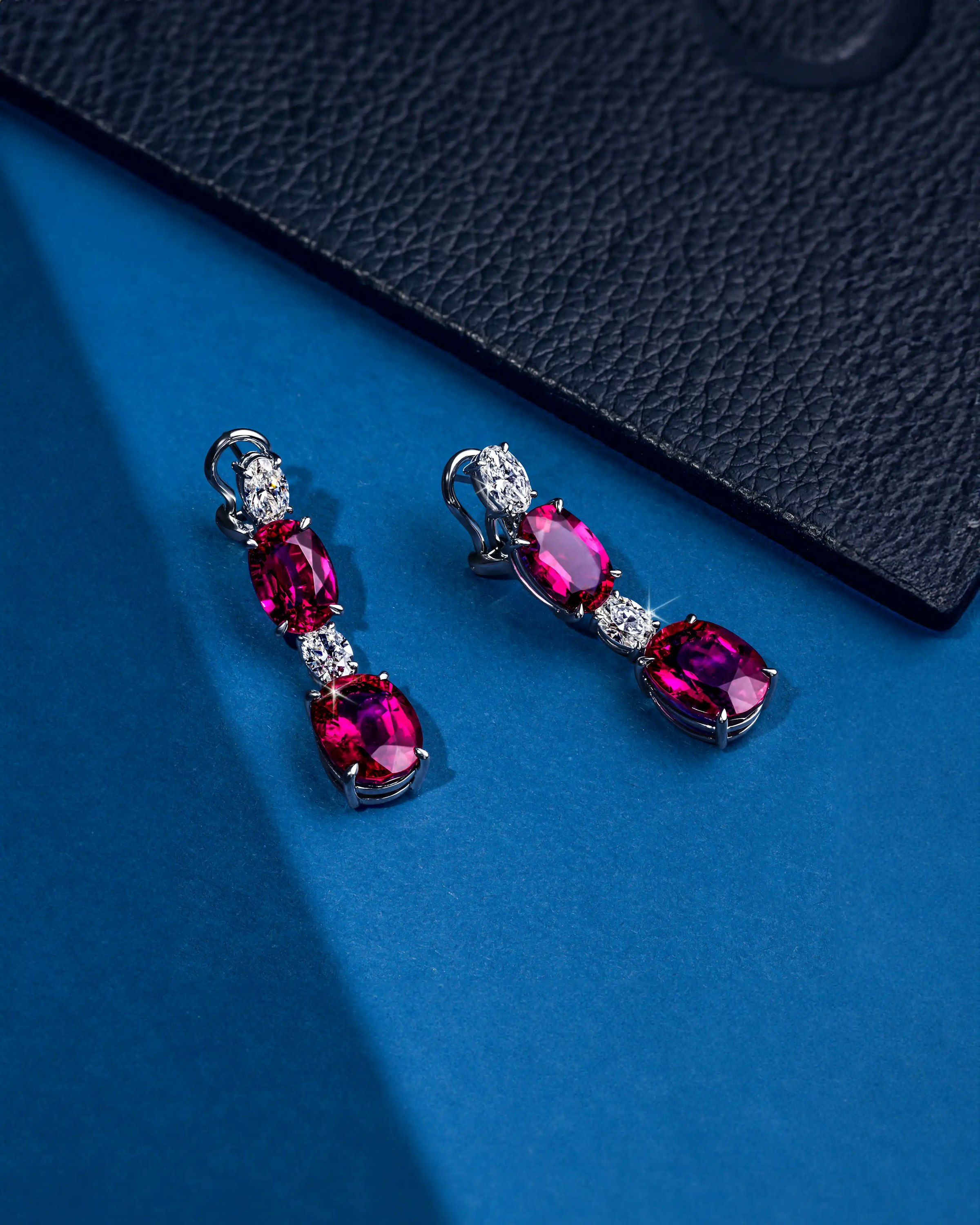 the earrings, laid on its hooks, as it is angled to the right