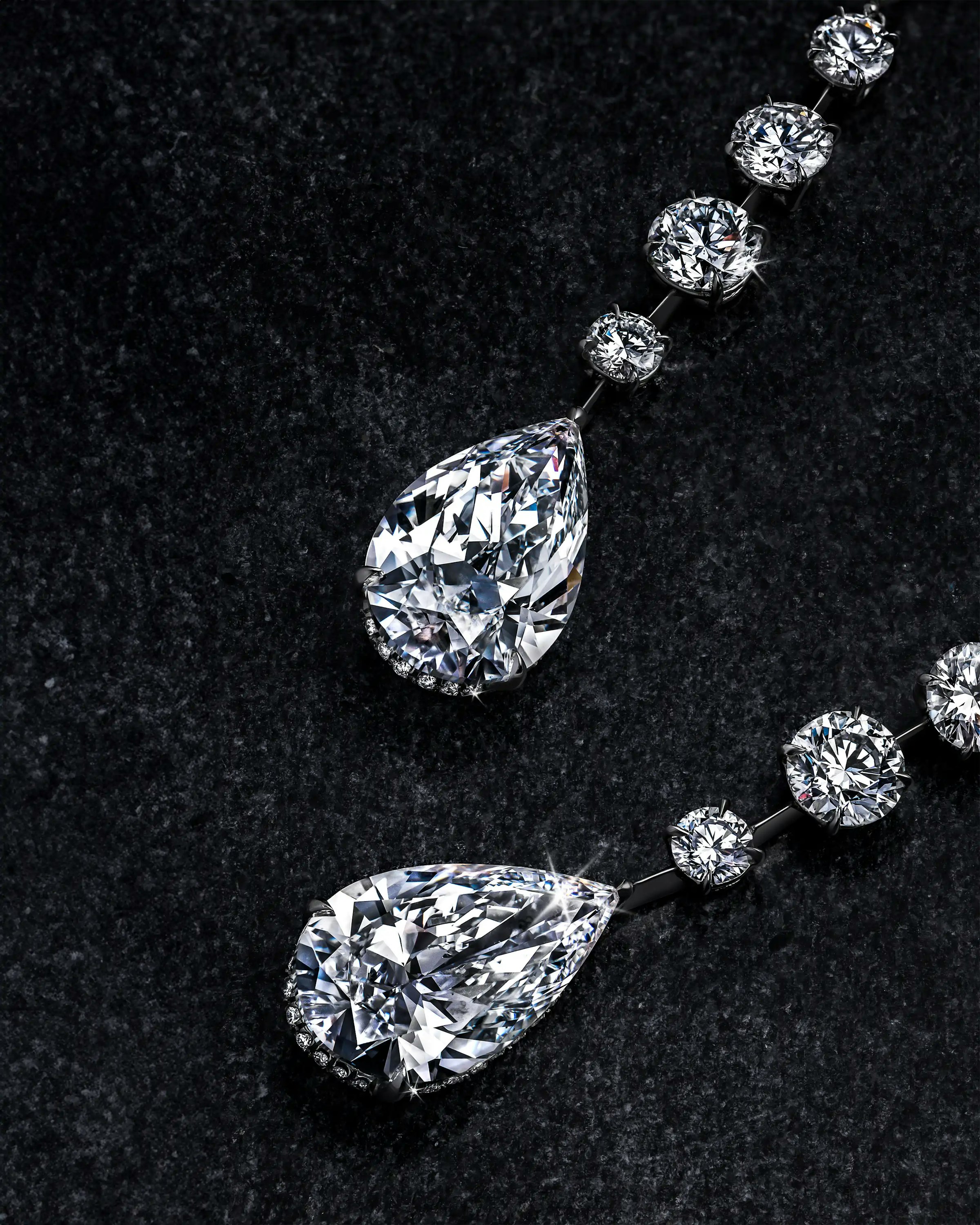 the white diamond teardrop earrings, laid flat on a surface.