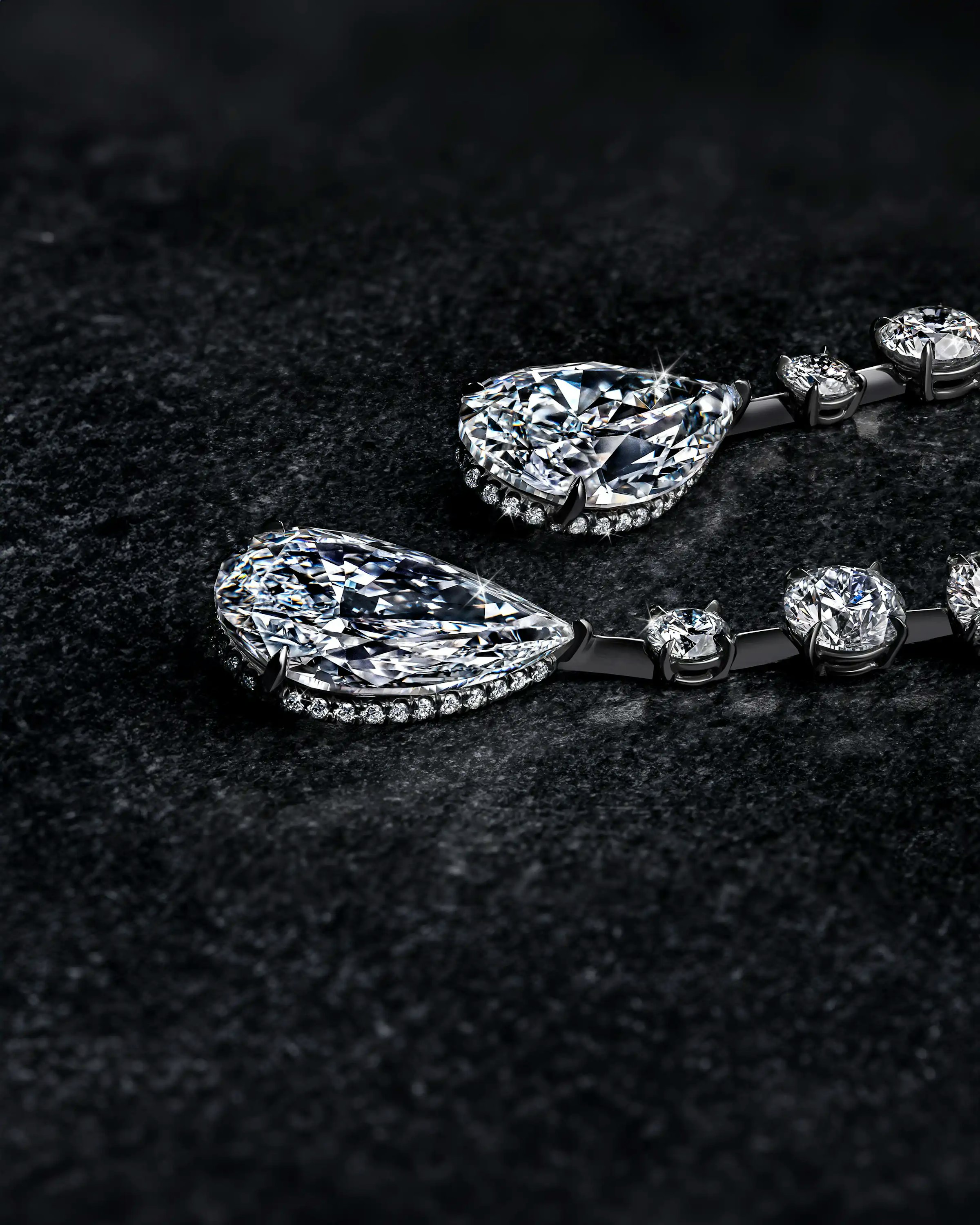 the white diamond teardrop earrings, laid flat on a surface.