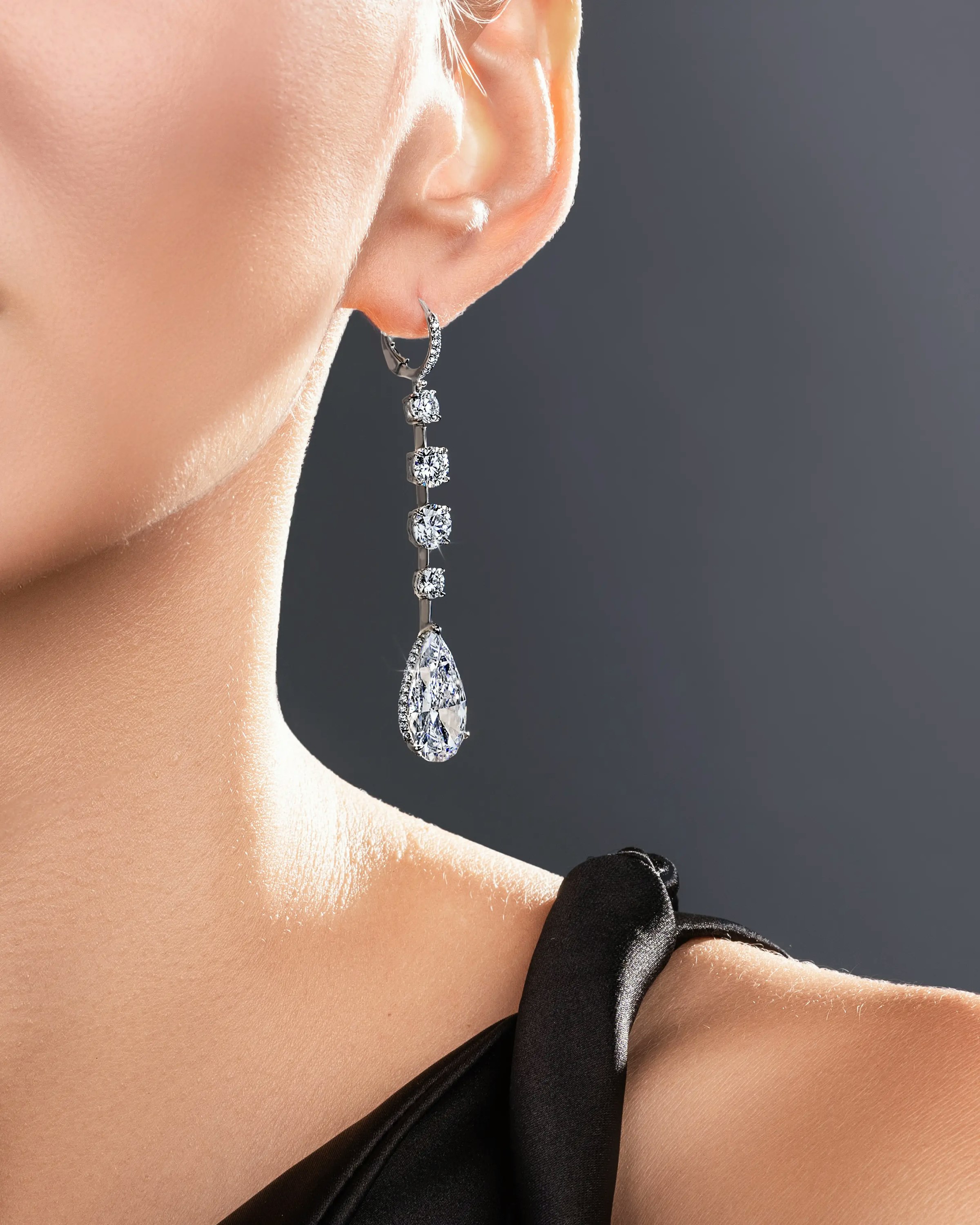a model wears the white diamond teardrop earrings.