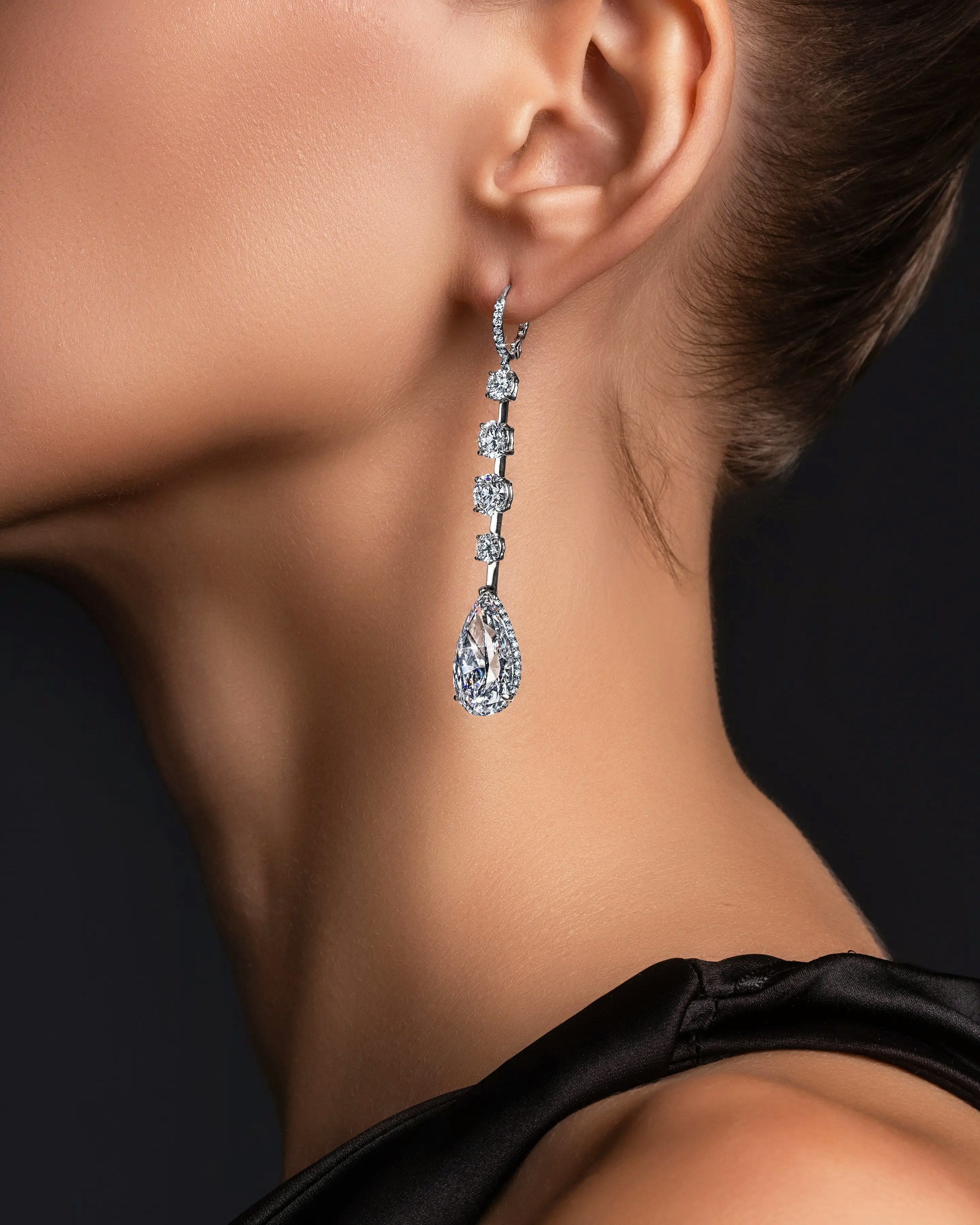 a model wears the white diamond teardrop earrings.