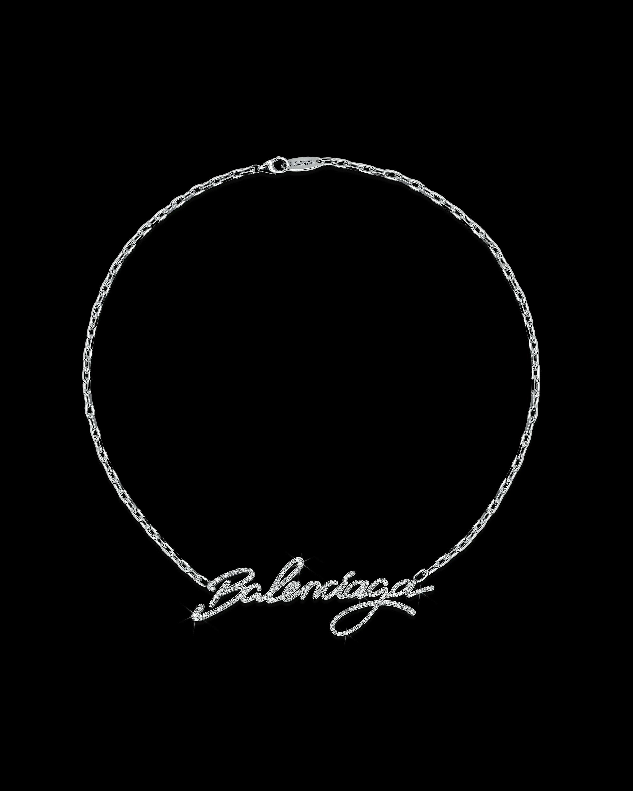 Image of a white gold necklace with a cursive typeface Balenciaga word as pendant
