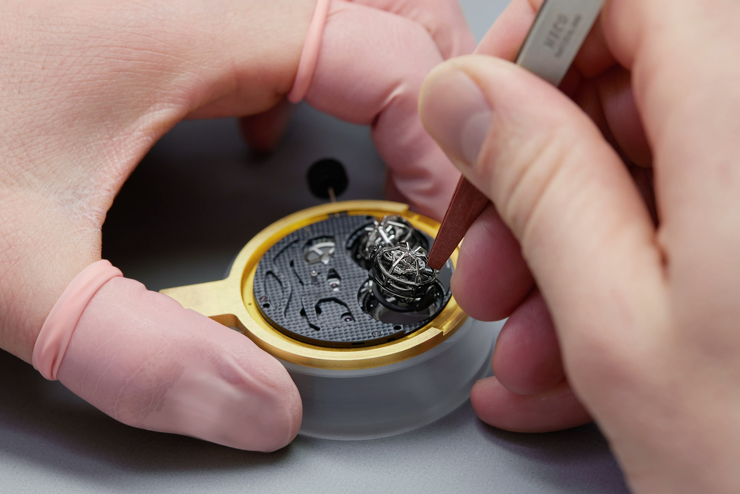 An image showing a watchmaker placing the tourbillon on a watch