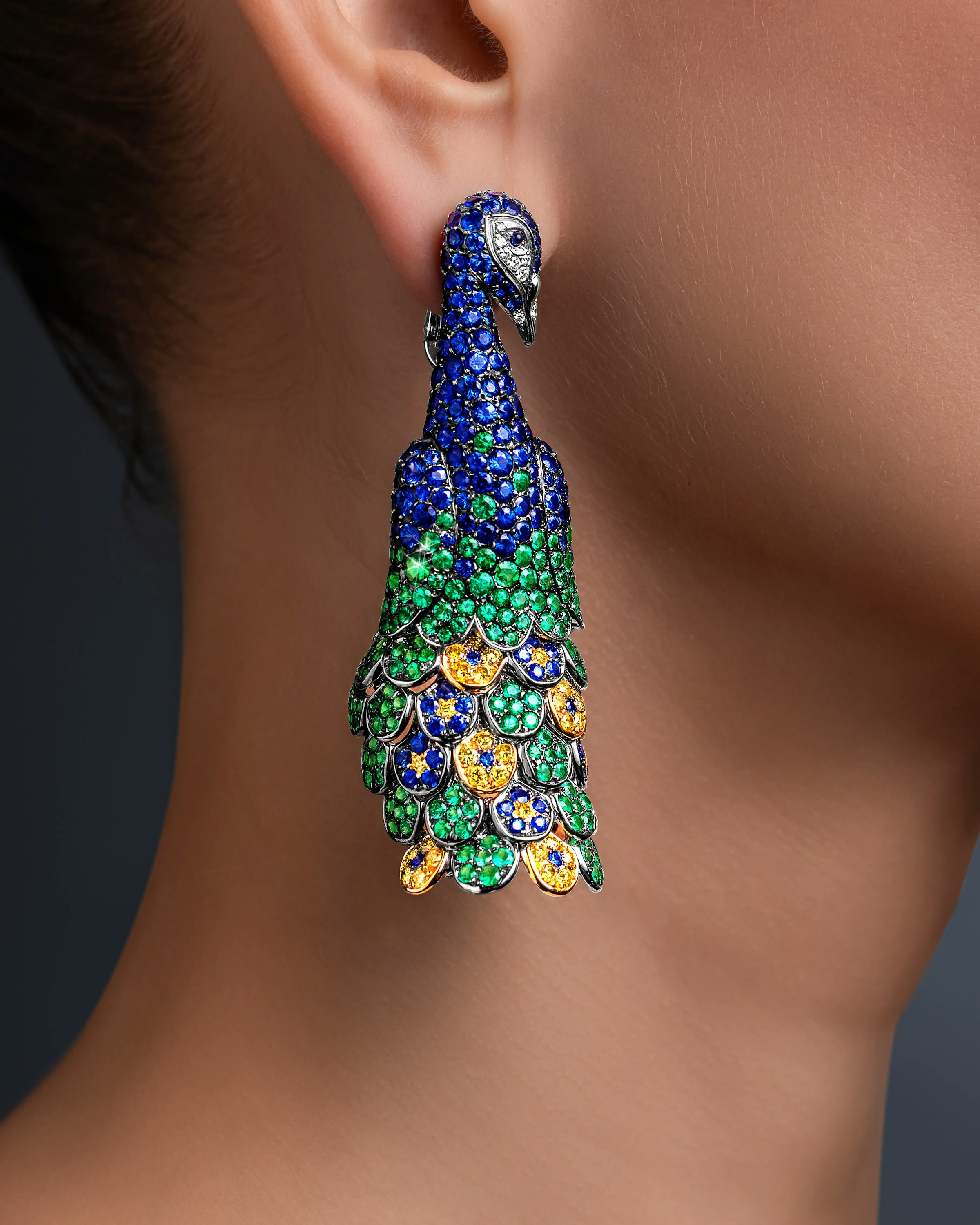 a model wears the twin peacock earrings.