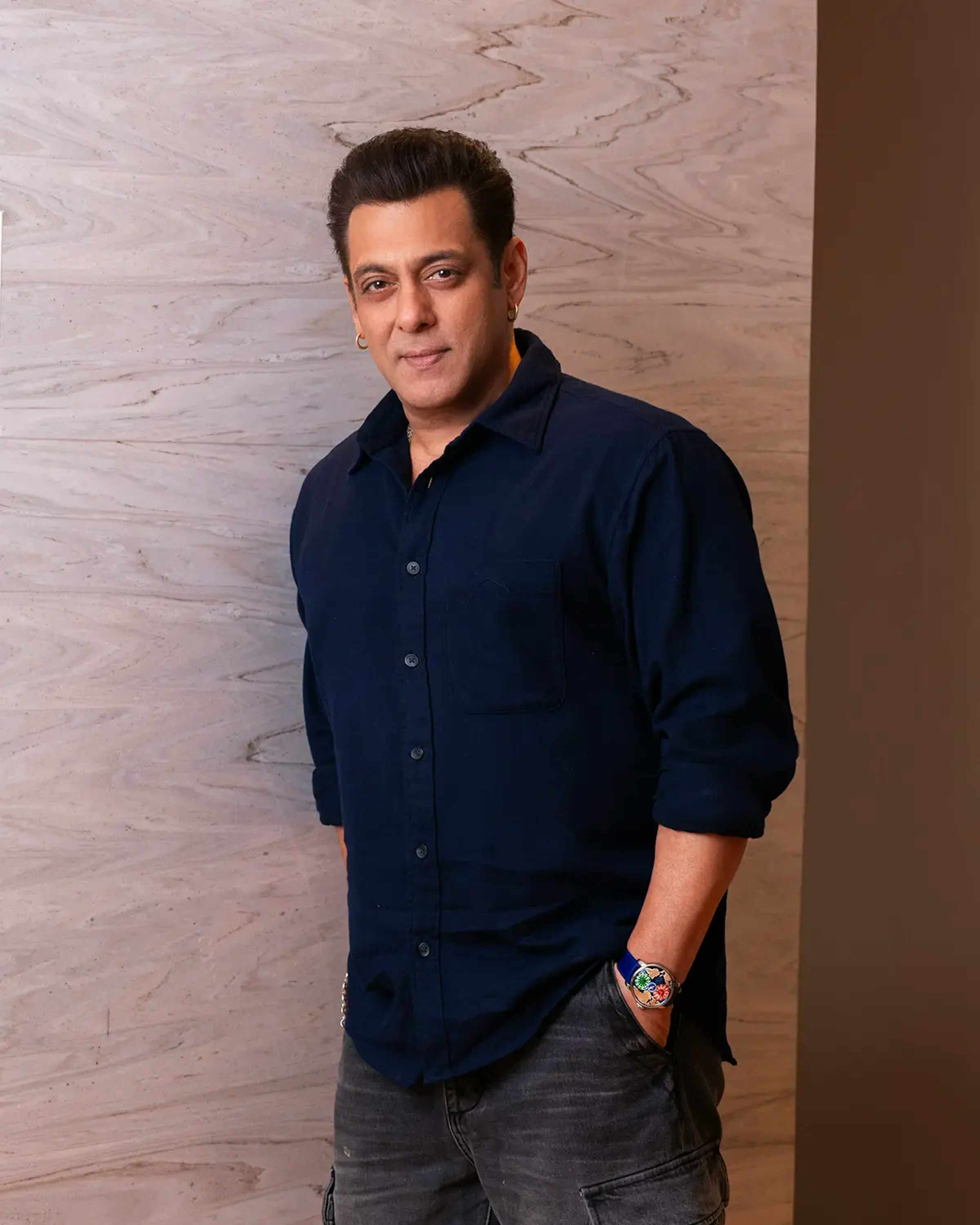 salman khan, standing, poses with the dual time zone salman khan watch worn on his left wrist.