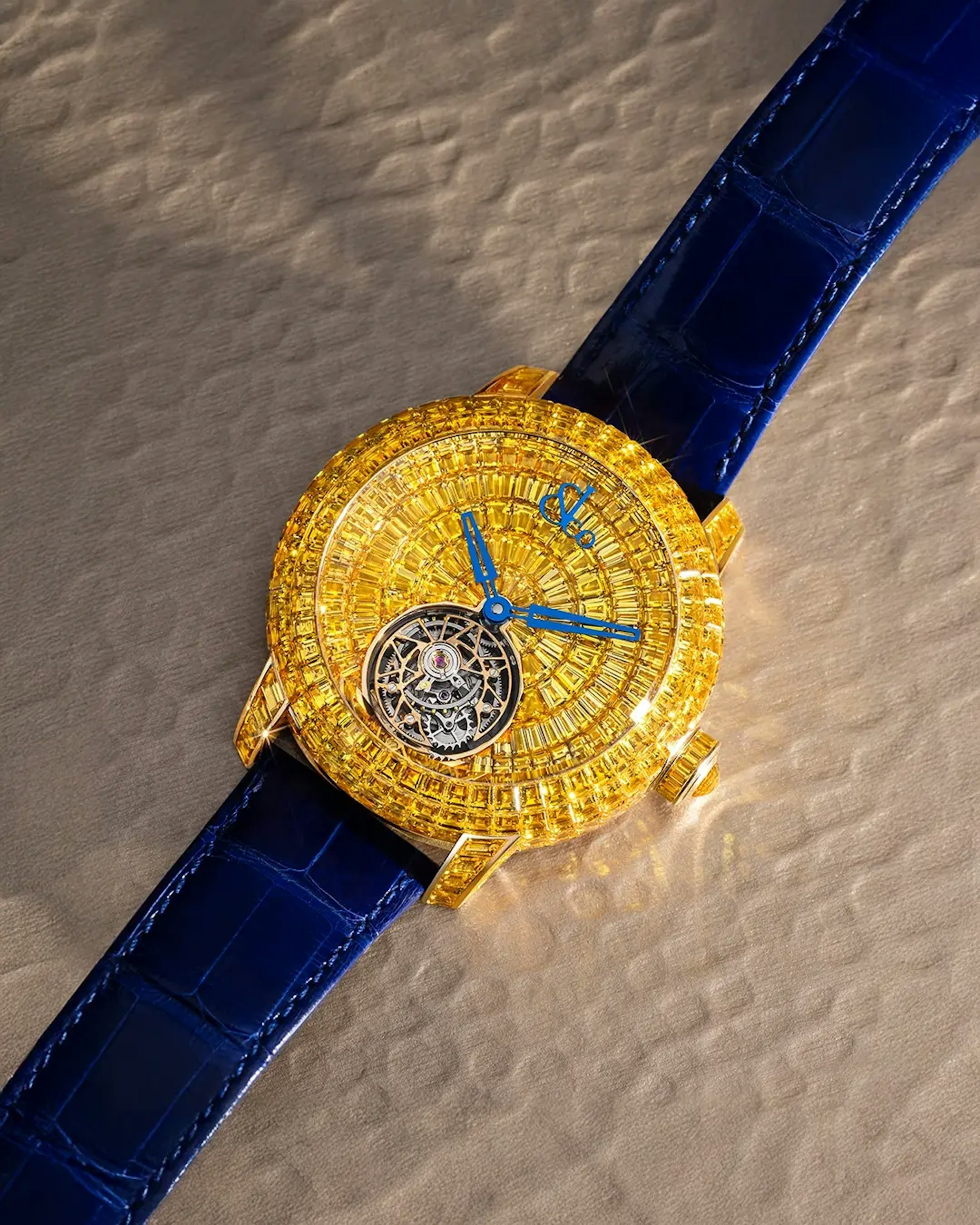 the yellow sapphire caviar tourbillon watch, laid flat on a surface